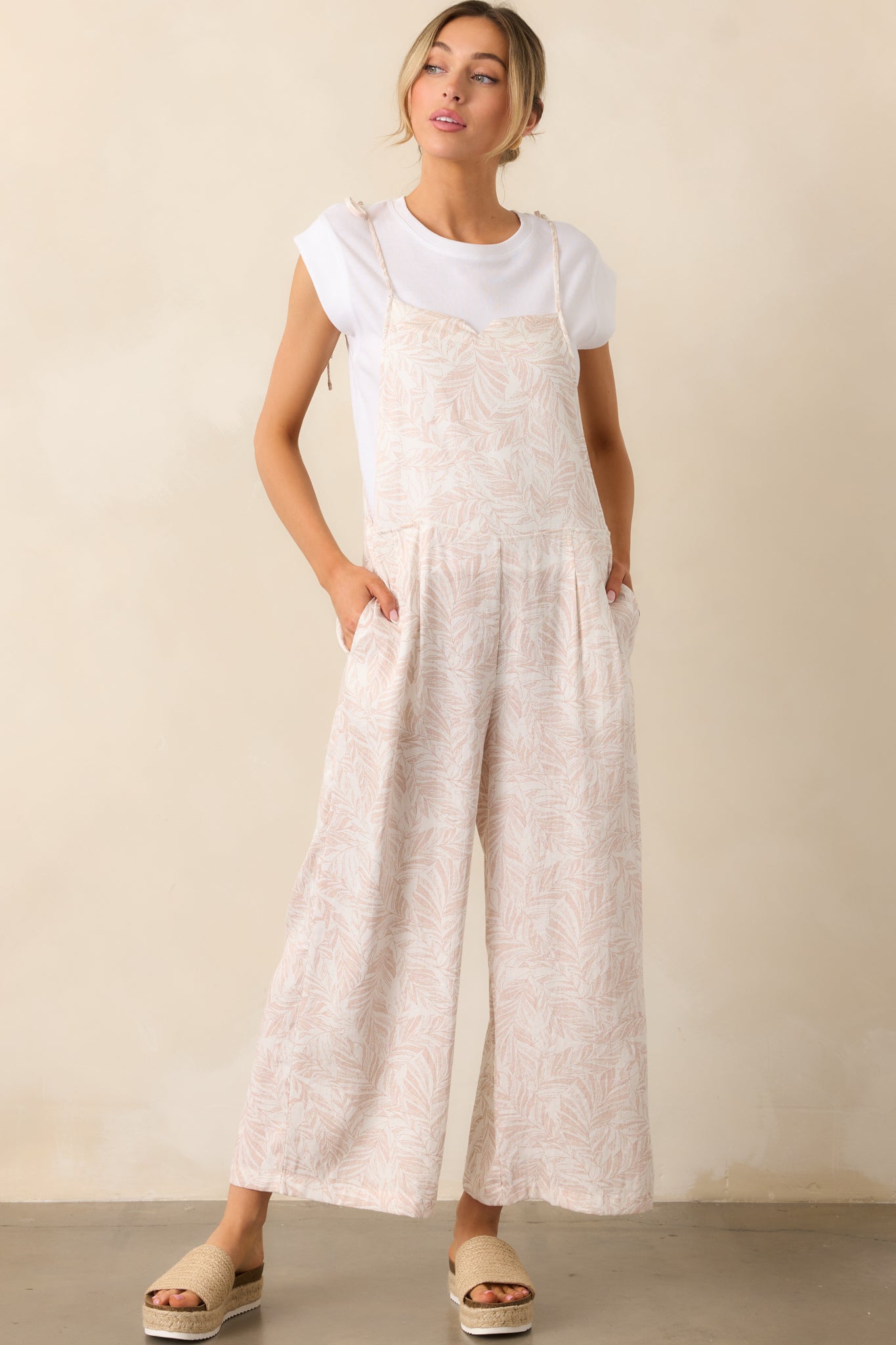 A side-angle view of the overalls, highlighting the relaxed fit and draping of the fabric.
