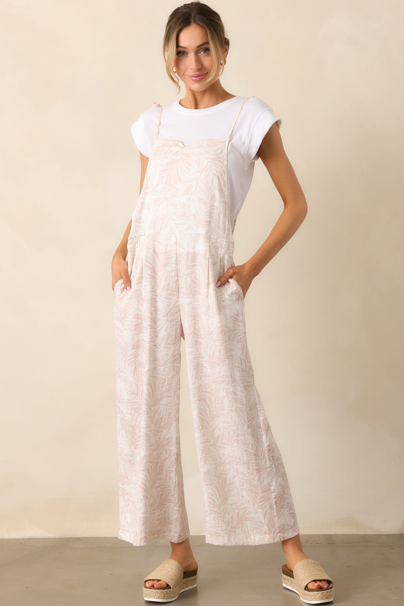 A front view of the natural overalls, showcasing the slitted square neckline and wide-leg design.