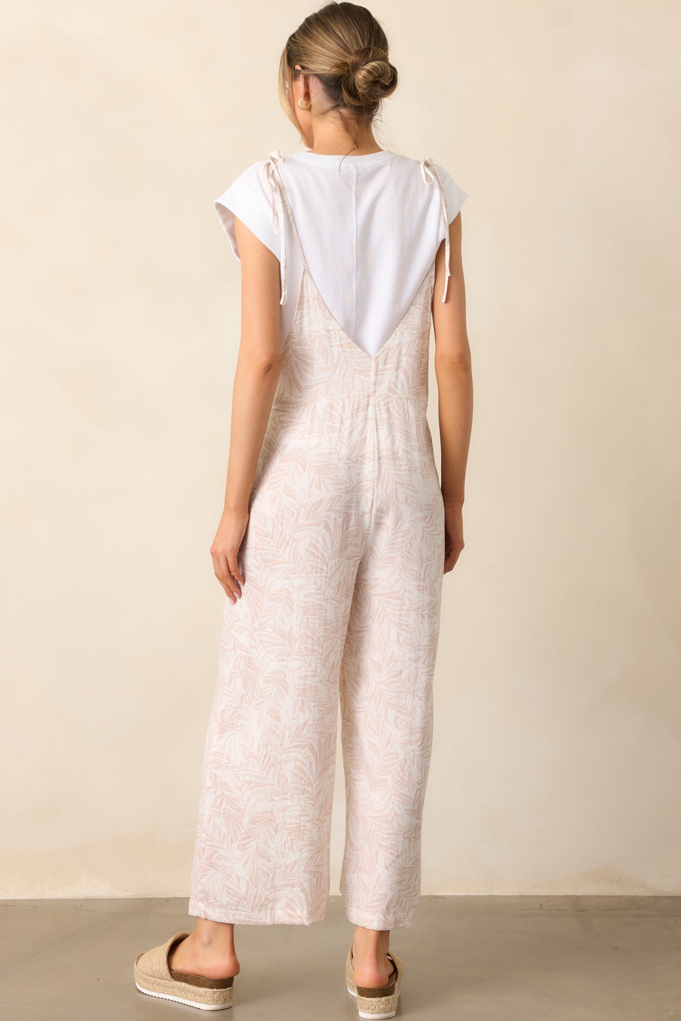 A full view of the back of the overalls, showing the adjustable tie straps and relaxed backline.