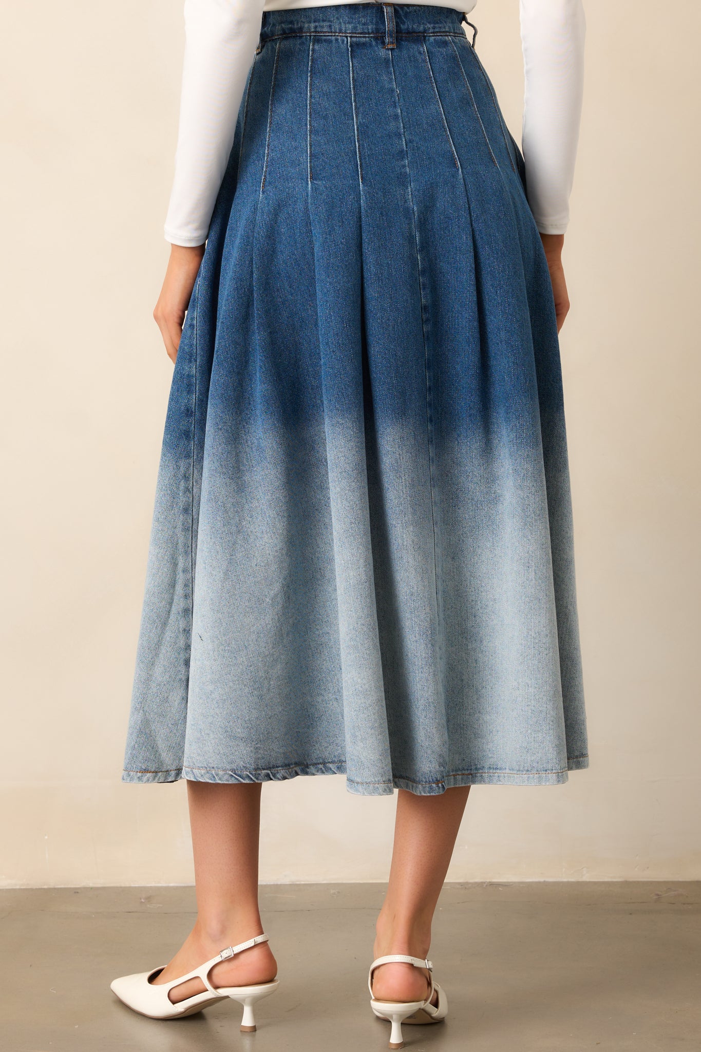 The skirt viewed from behind, displaying its high-waisted structure, belt loops, and ombré color fade.