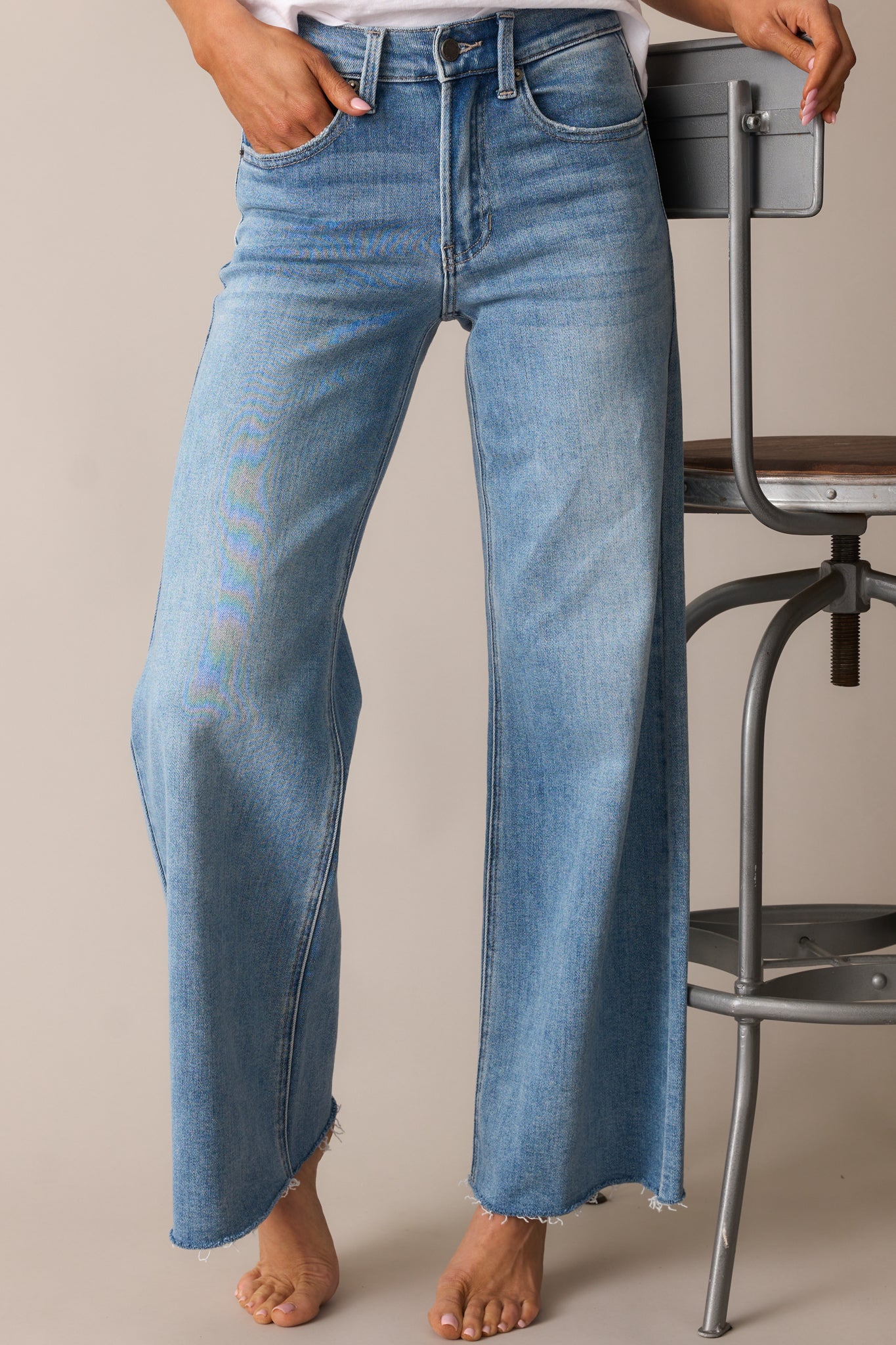 A detailed view of the wide straight-leg jeans, highlighting the raw bottom hem and relaxed fit.
