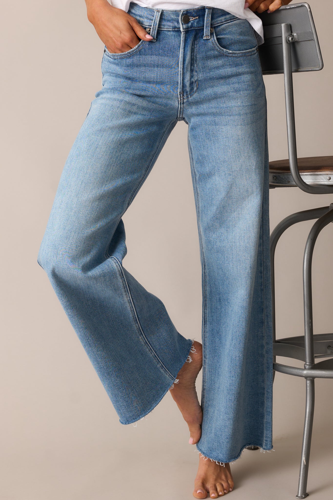 A closer look at the medium wash jeans’ high-waisted design, showcasing the structured waistband, belt loops, and functional pockets.