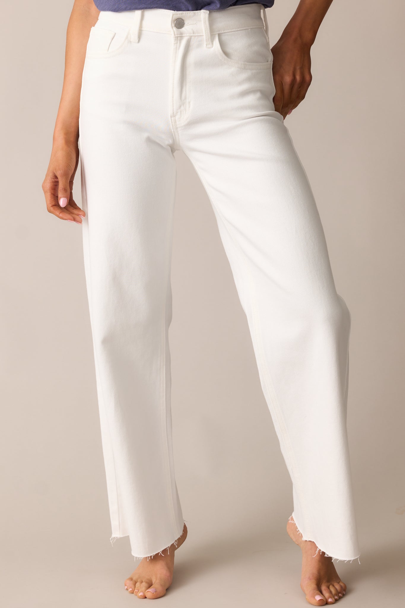 A closer look at the jeans’ high-waisted fit, belt loops, and functional front pockets, highlighting the clean white denim.