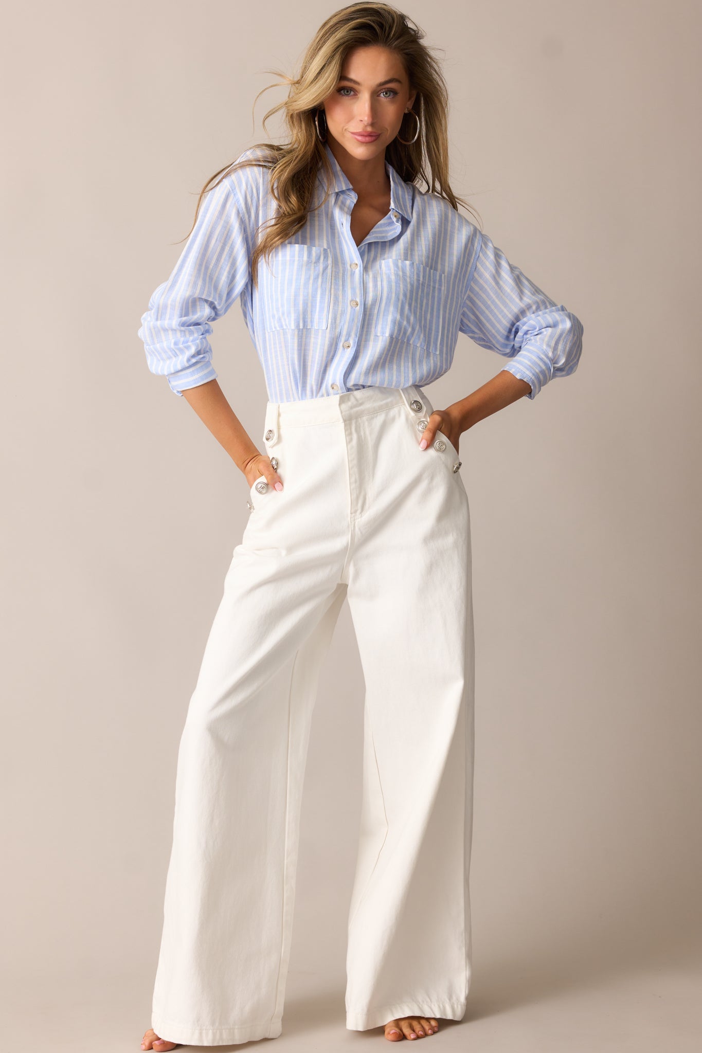 Blue stripe top with a collared neckline, button front design, vertical stripe pattern, and long sleeves with buttoned cuffs.