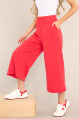 These red pants feature a high waisted design, an elastic waistband, functional hip pockets, a textured crisscross design, and a wide leg.