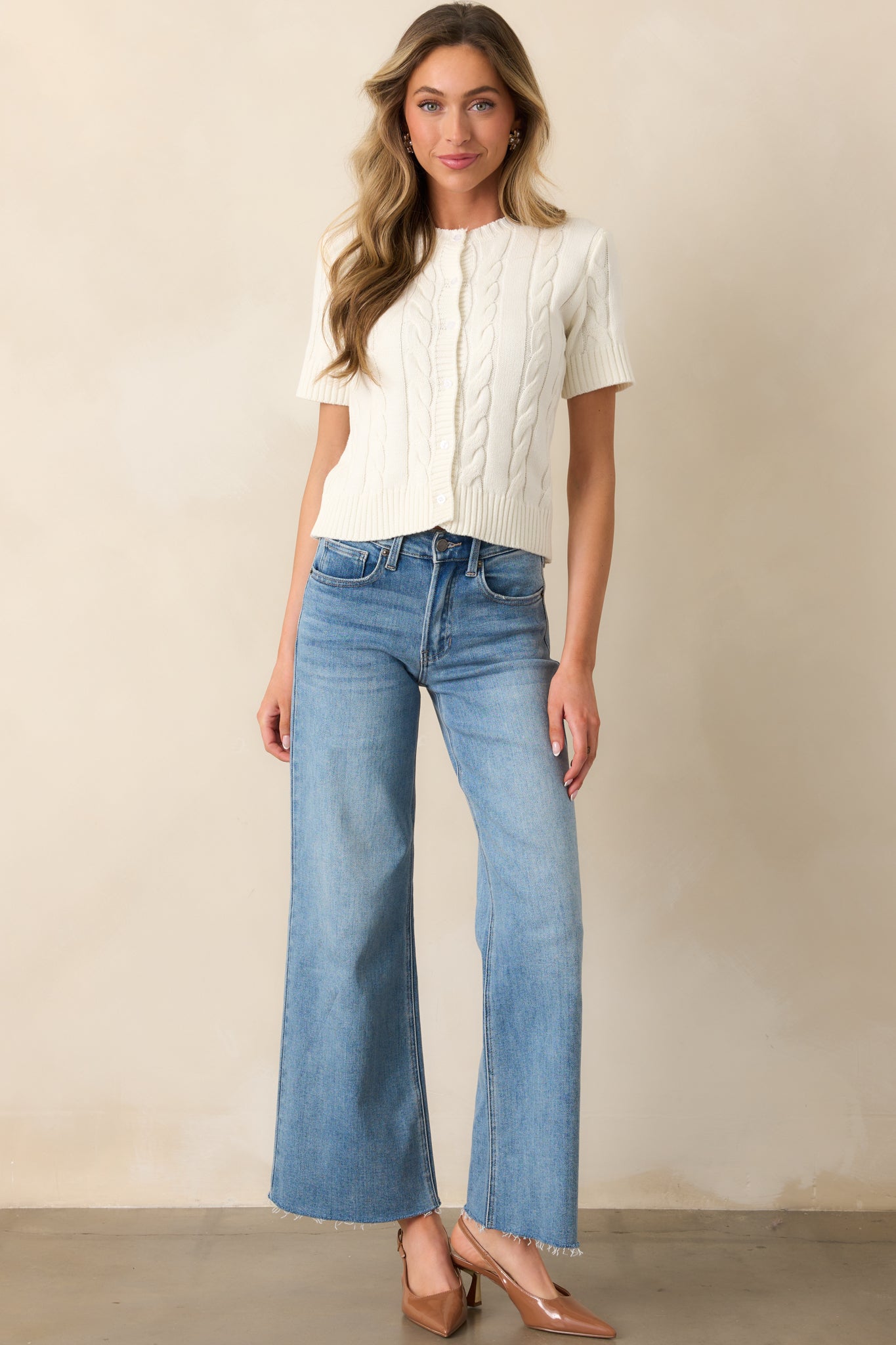 Medium wash jeans featuring a high waist, classic button and zipper closure, and a relaxed wide-leg silhouette.