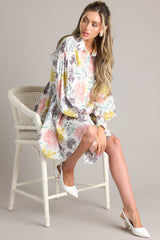 This multi-colored dress features a collared neckline, functional buttons down the front, long balloon sleeves with smocked cuffs, and a flowy, relaxed fit throughout.