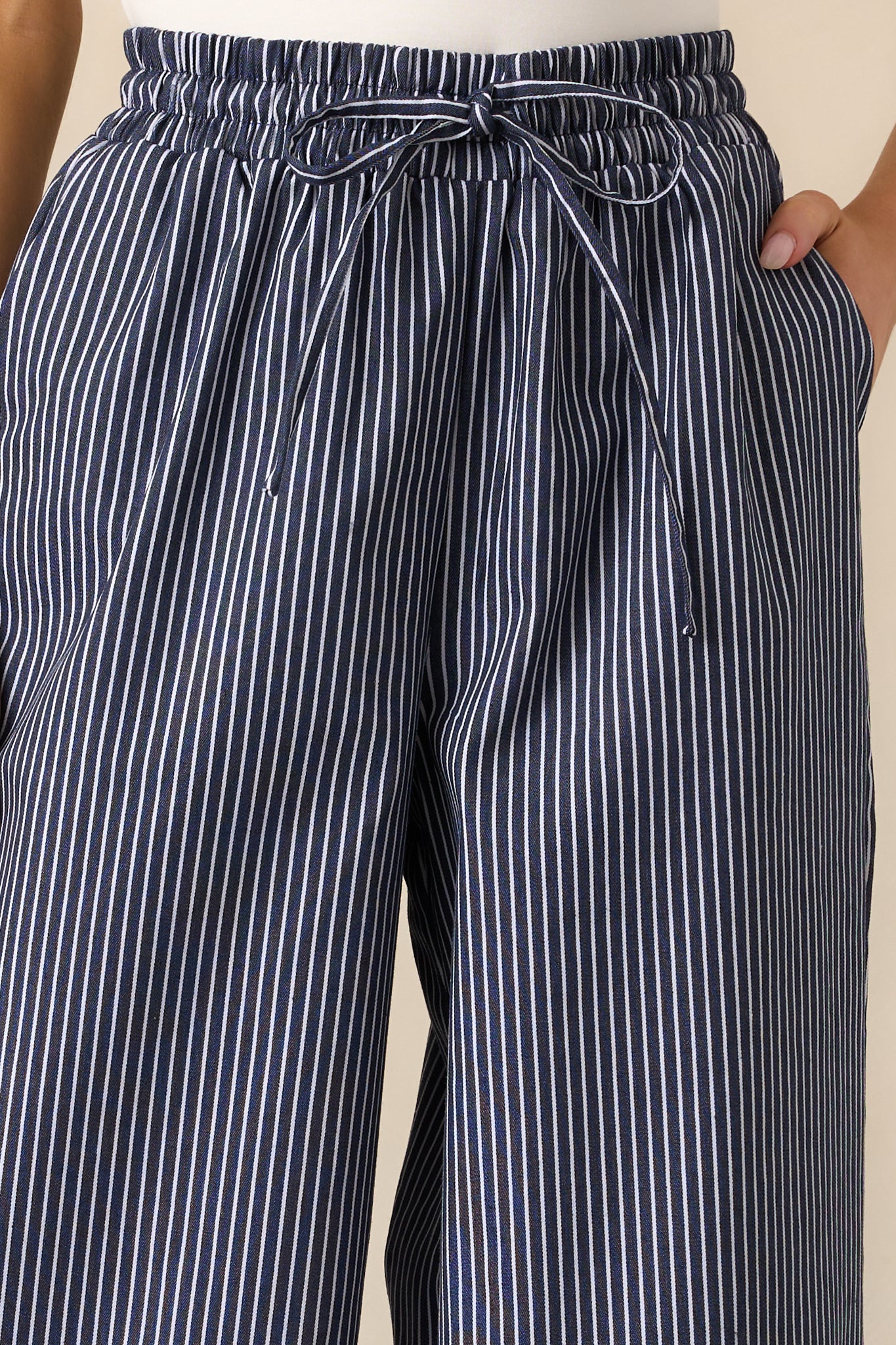 Close-up of the striped design on the navy pants, highlighting the pattern and fabric texture, along with the adjustable drawstring waistband.