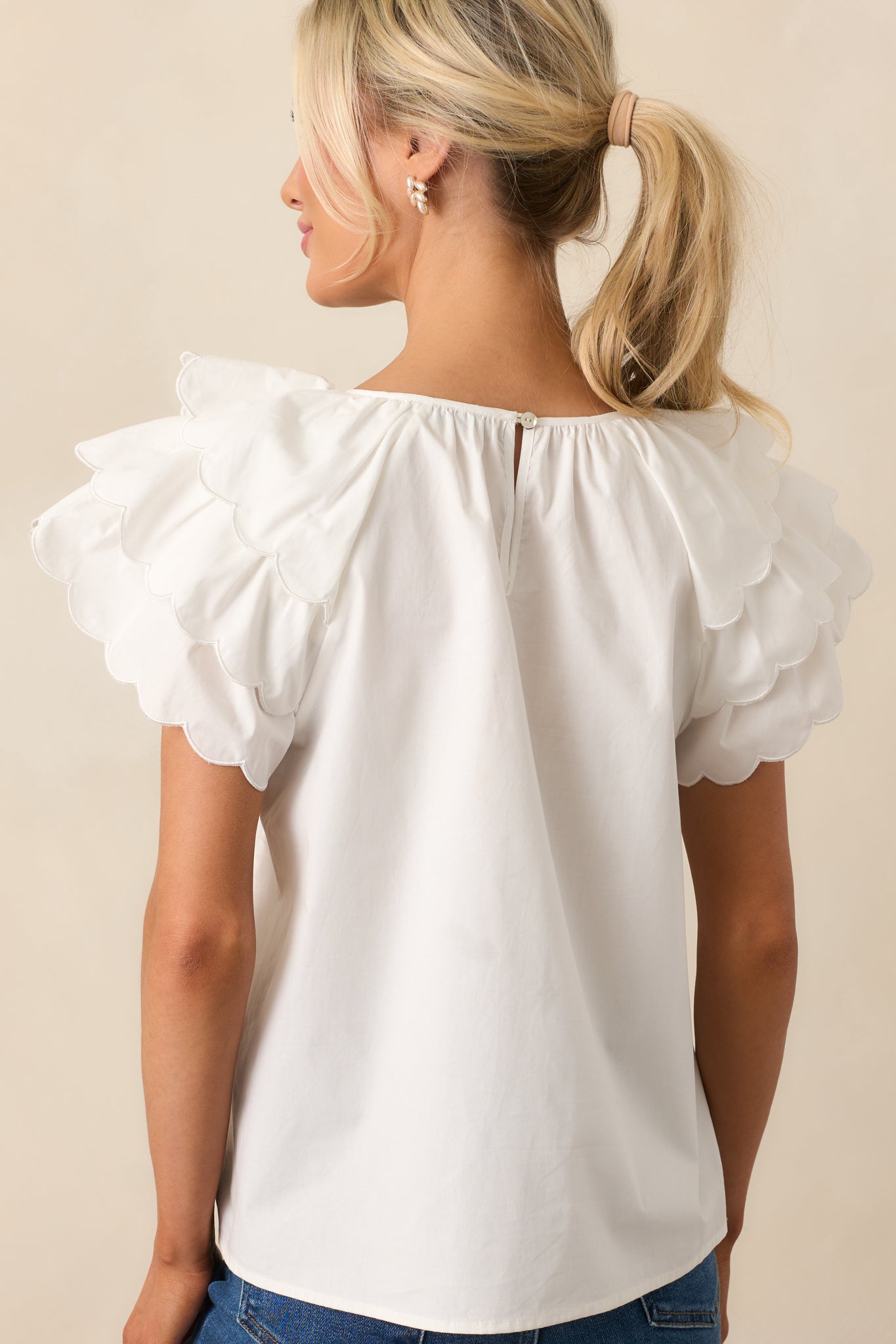 The back view of this white top reveals the keyhole closure, adding a touch of elegance to the simple, flowy design.