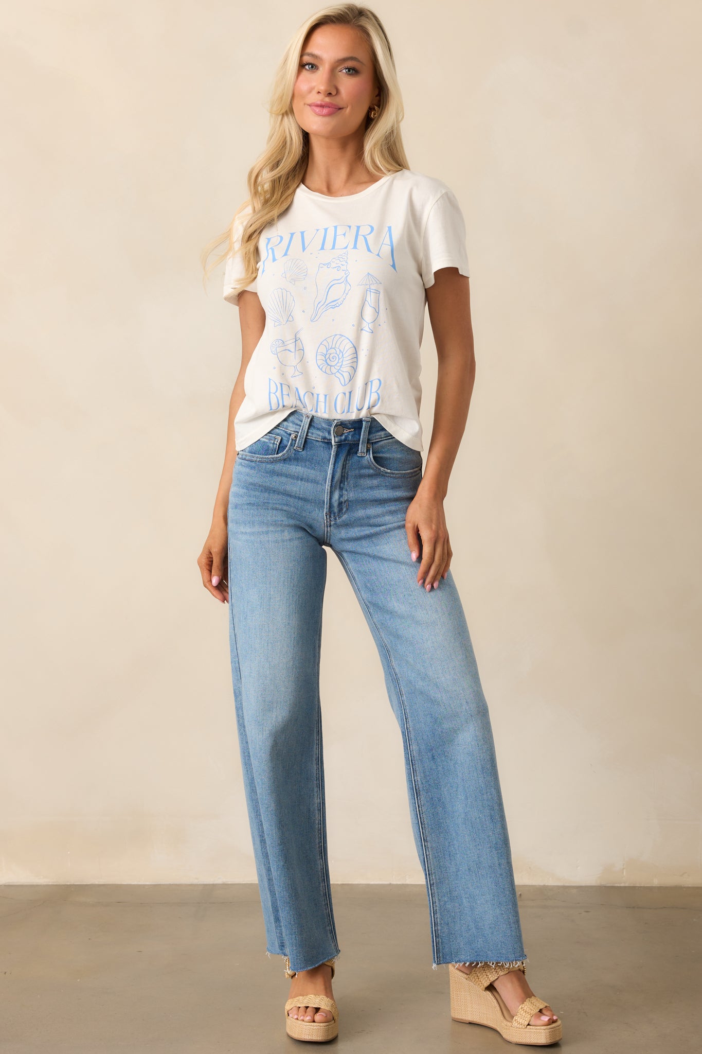 Medium wash high-waisted jeans with a wide straight-leg fit, functional pockets, and a raw bottom hem.