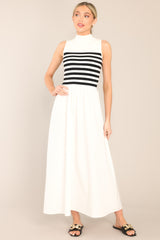Full body view of this dress that features a high neckline, a striped sweater bodice, and a flowy skirt.
