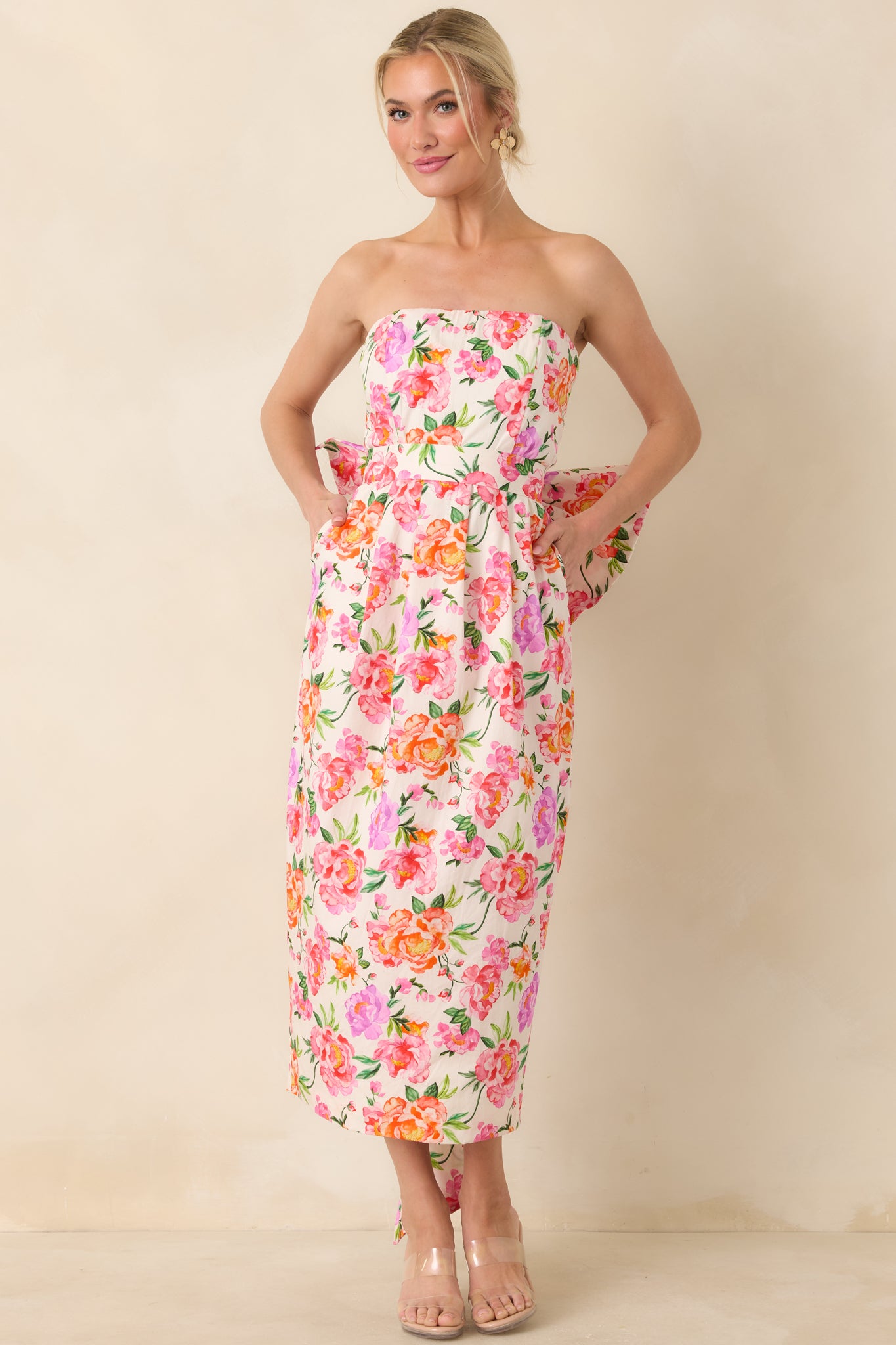 Pink floral strapless midi dress highlighting a fitted bodice, flowing skirt, and coordinated structure that accentuates the waist.