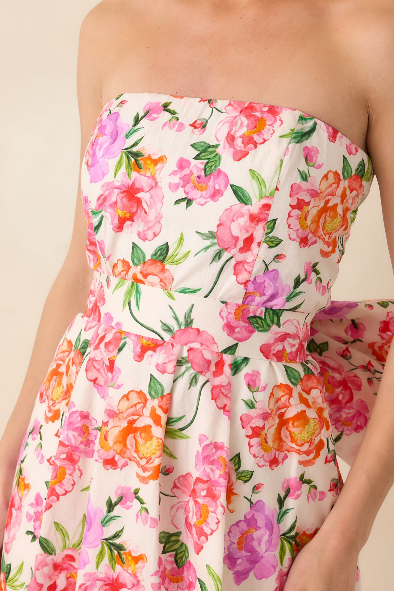 Detailed view of the vibrant pink floral fabric and fitted bodice with smooth cotton texture.