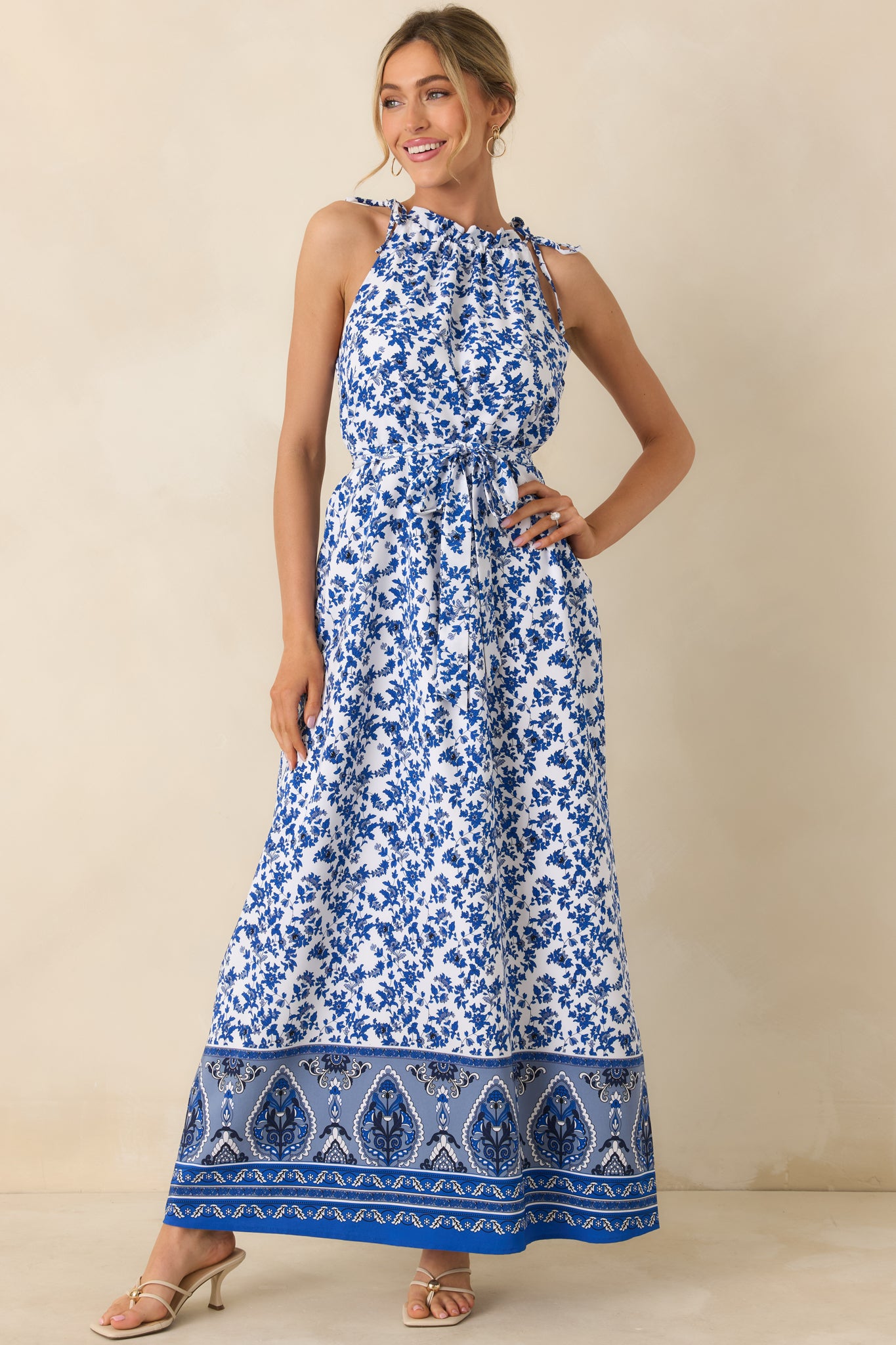 Front view of blue floral dress featuring functional side pockets, belt loops, and tiered skirt.