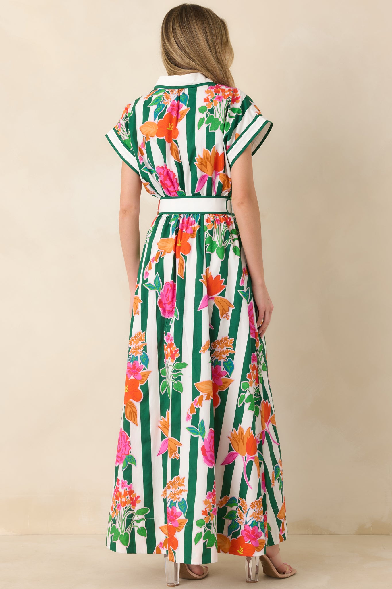 Back view of the green multi floral stripe maxi dress showing the flowing skirt, short sleeves, and coordinating belt at the waist.