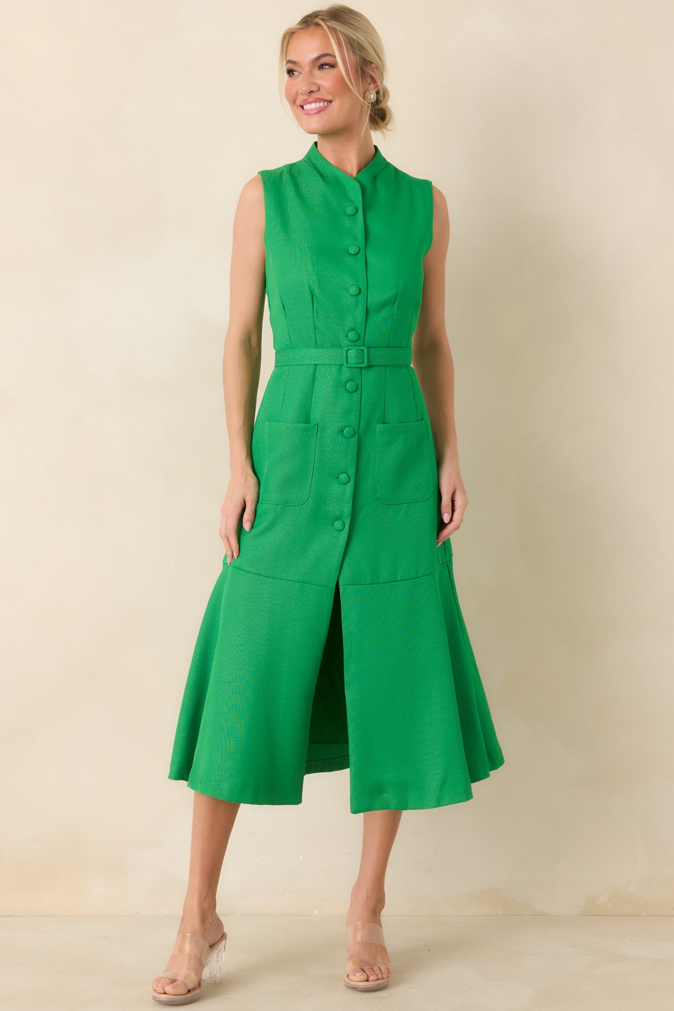 Vivid green midi dress with a sleek stand collar, covered front buttons, shaping seam details, coordinating waist belt, patch pockets, and a softly flared skirt.