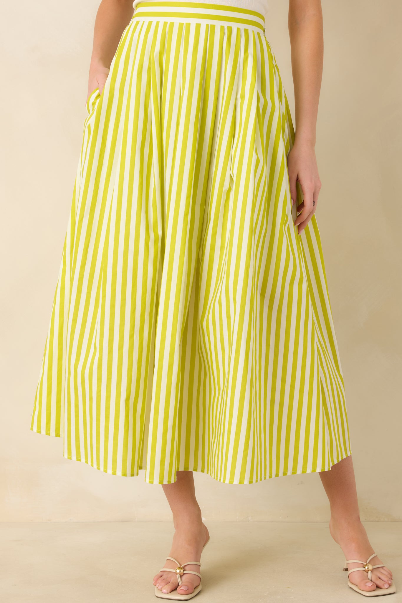 Cropped view showing the volume and soft drape of the green woven cotton skirt fabric.
