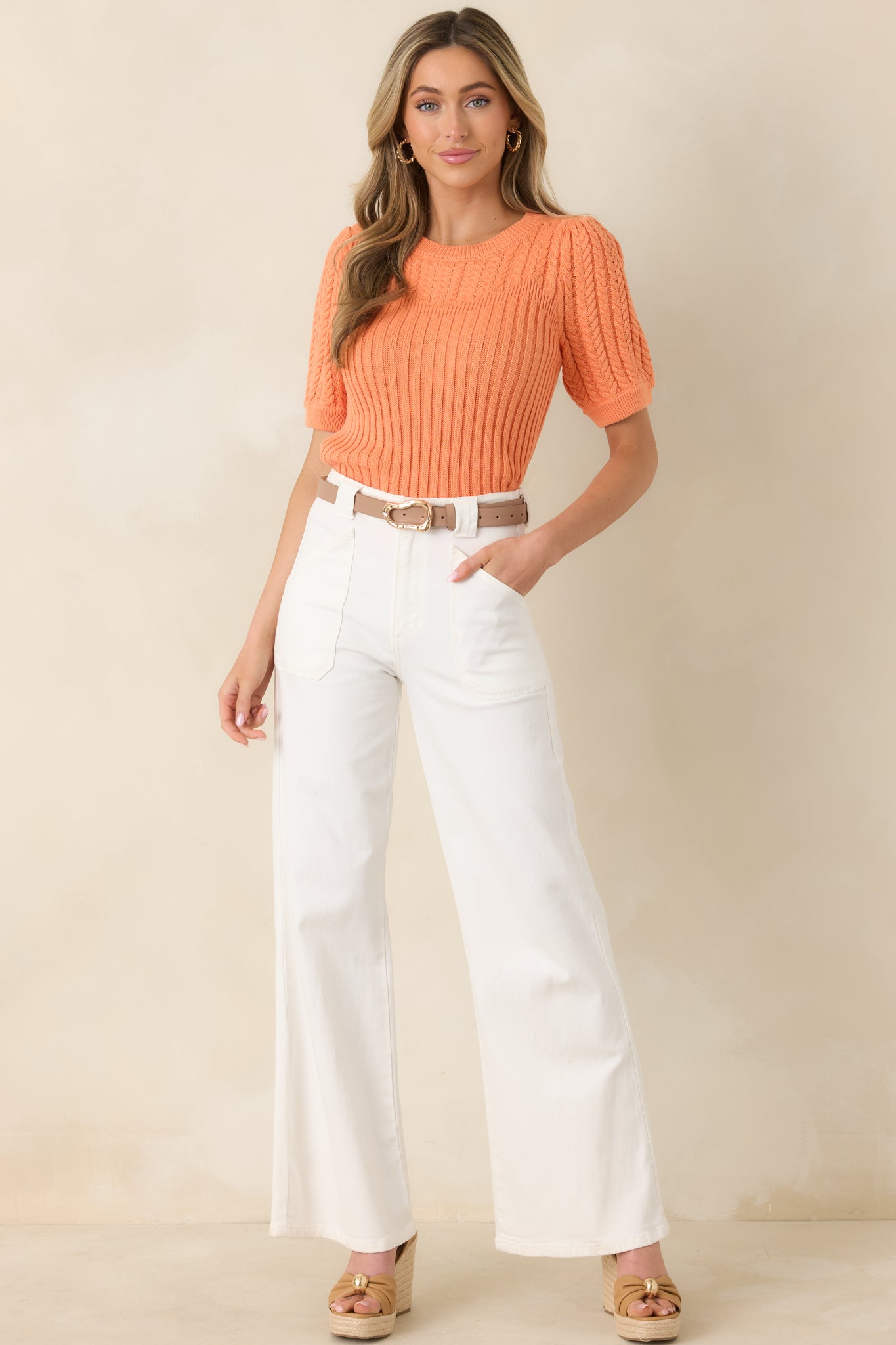 Fitted ribbed top with voluminous short sleeves, classic crew neck, and textured cable knit design for a flattering seasonal silhouette.