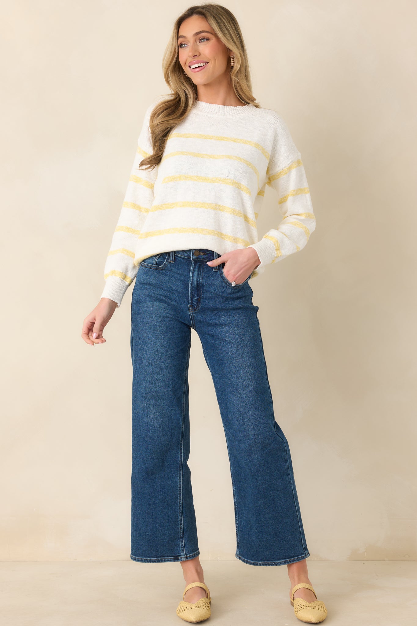 Cream-toned sweater featuring yellow stripes, ribbed cuffs, and a ribbed hemline for a polished finish.