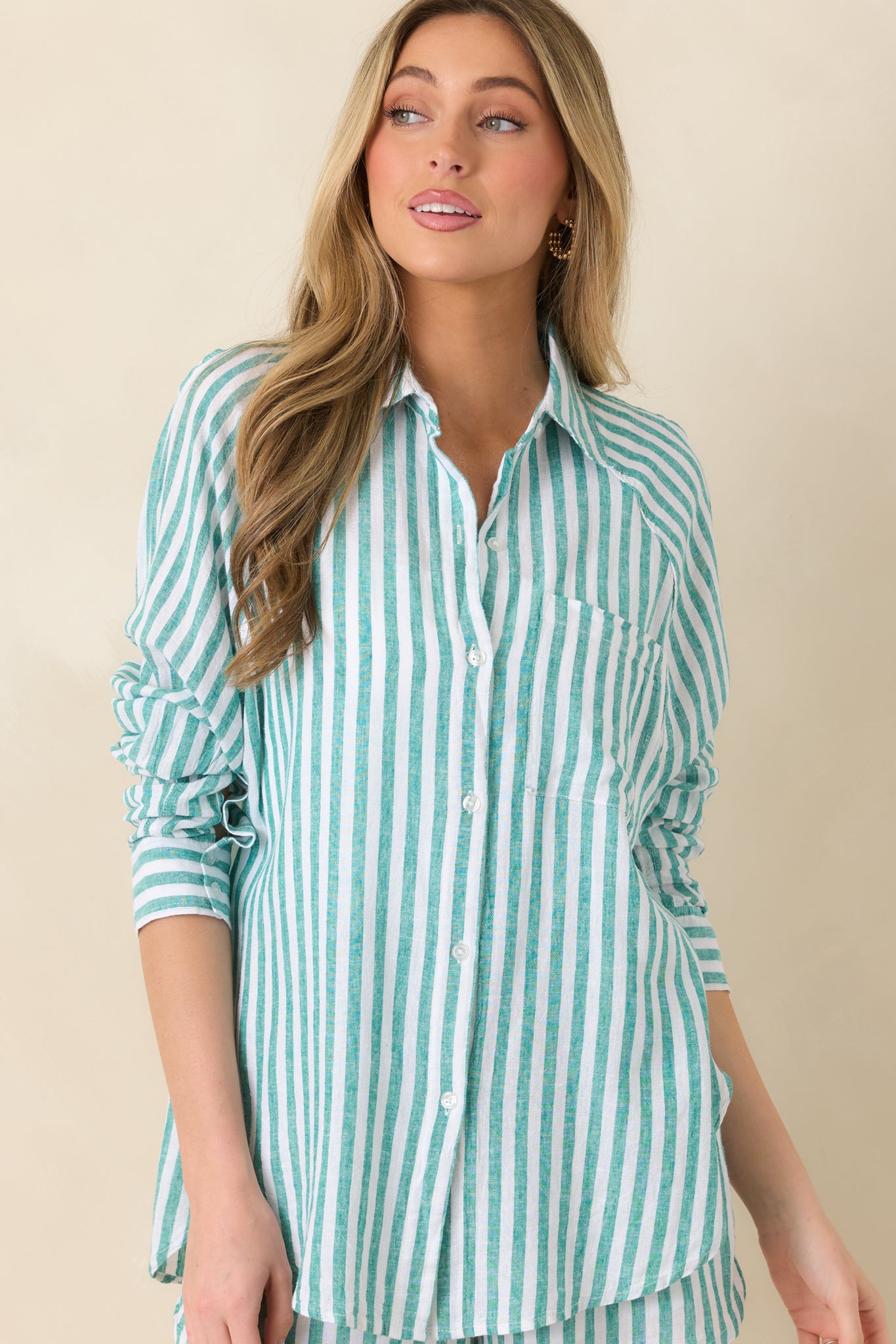 Close-cropped view of green and ivory striped button-up top highlighting the collar, chest pocket, and soft linen texture.