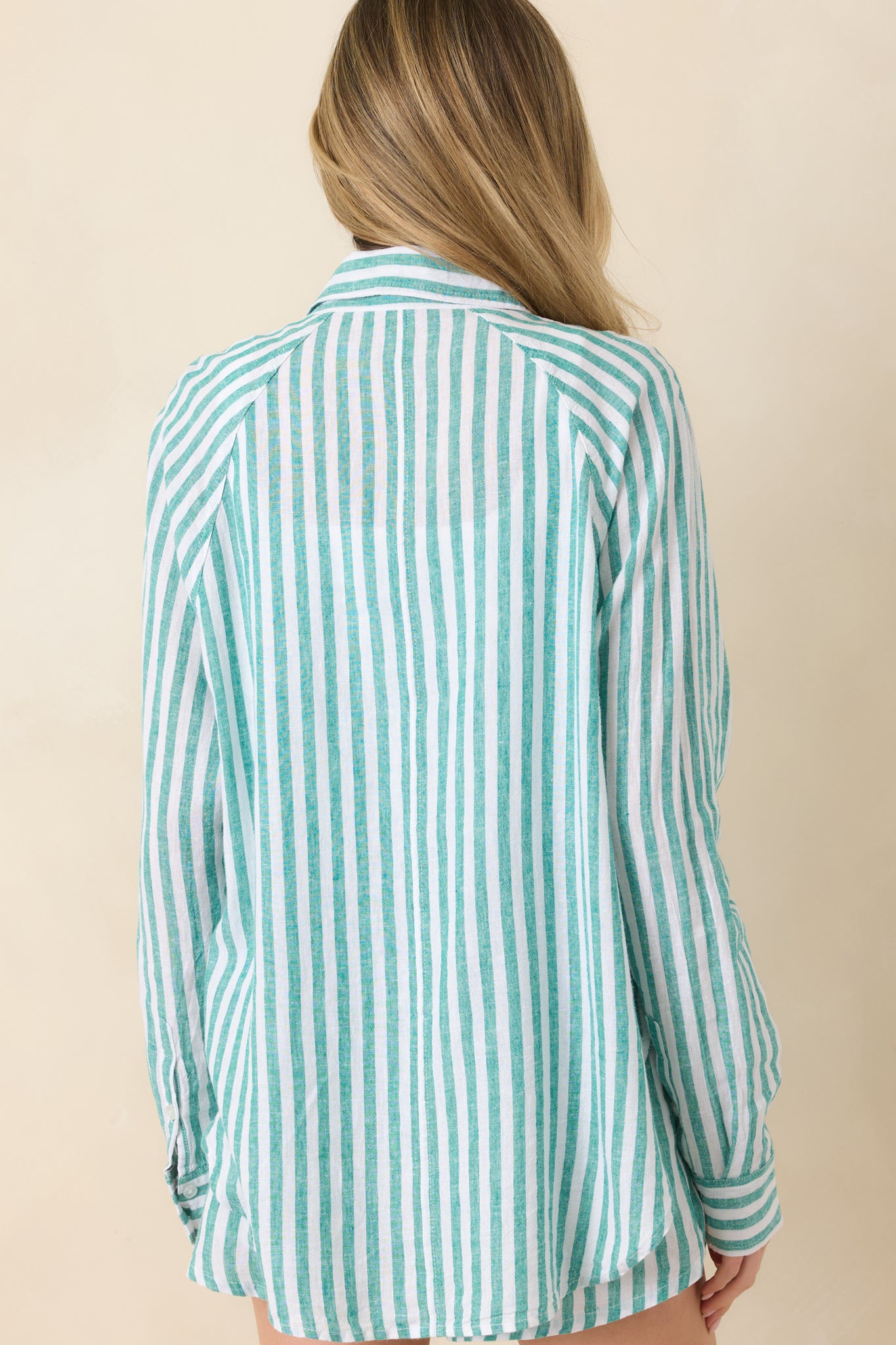 Back view of green and ivory striped linen top featuring a relaxed fit, clean vertical lines, and a softly draped silhouette.