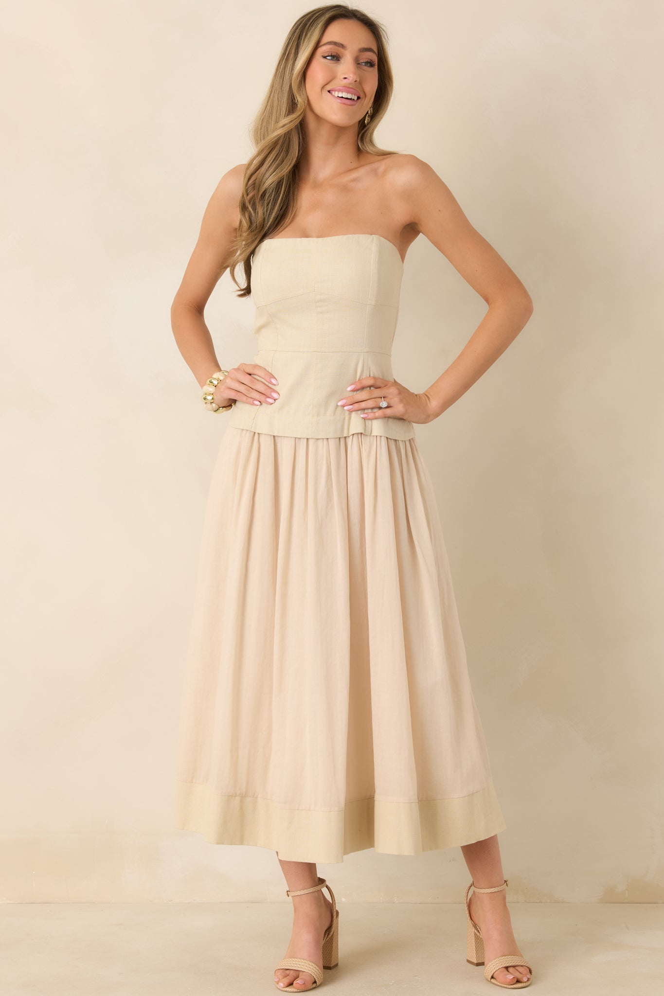 Front-facing view of adjustable-strap midi dress with structured bodice and airy skirt silhouette.
