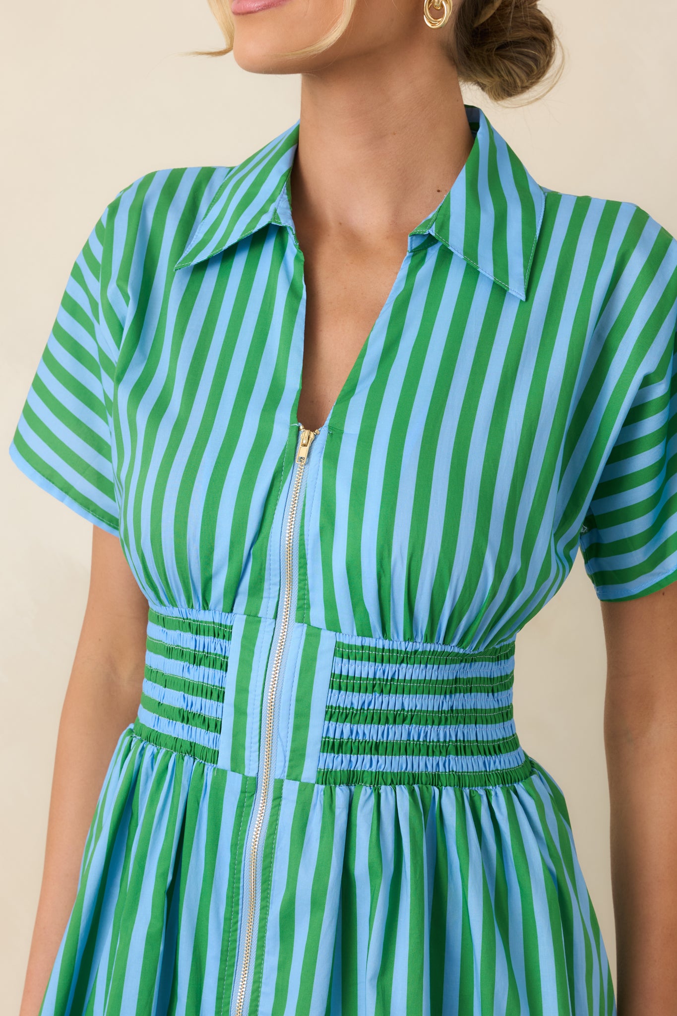 Close-up of the fabric’s light blue and green stripes, smocked waistband, and zip-front detail.