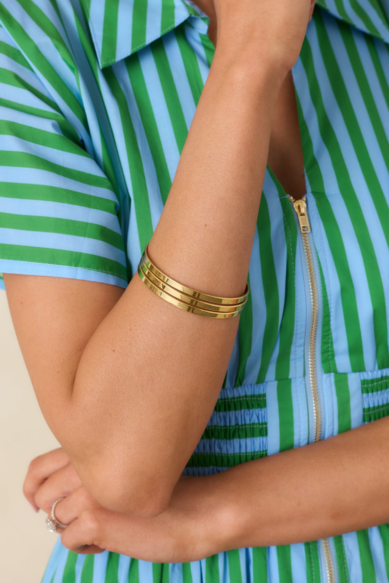 Gold bangle bracelet set featuring multiple slim bands styled together for a minimalist stacked look.