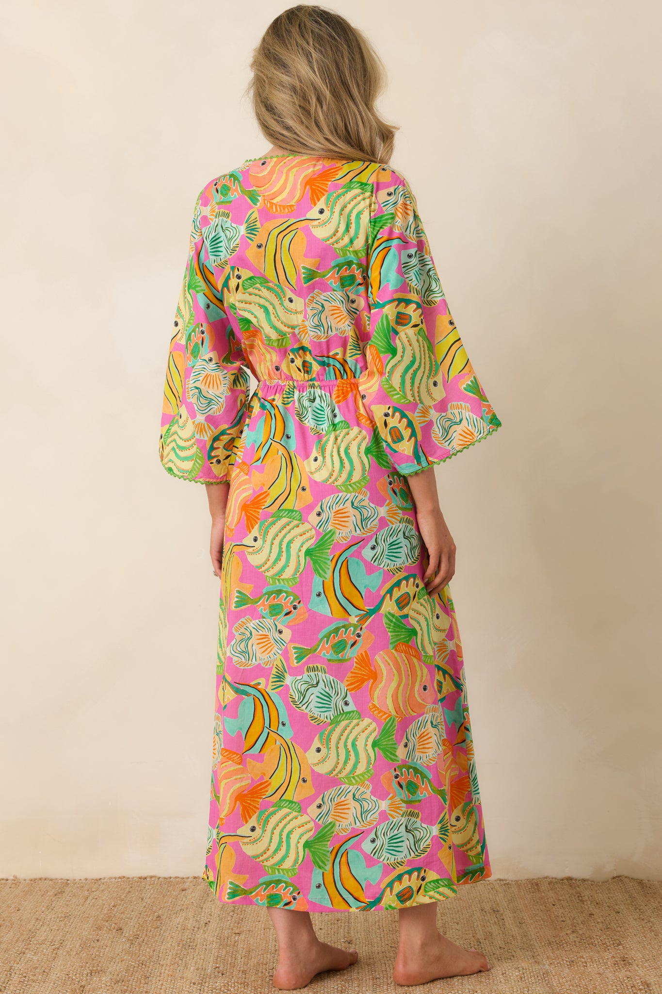 Rear view of the dress showing billowy sleeves, adjustable waist, and lively ocean print.