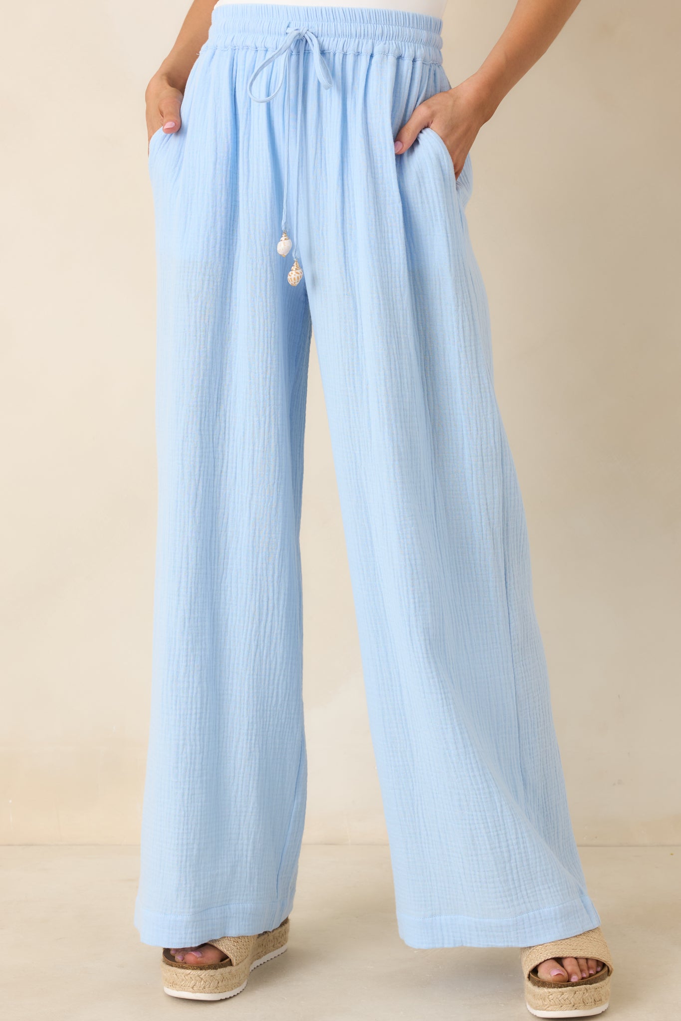 Decorative tassel on drawstring tie and textured lightweight cotton fabric on blue pants.