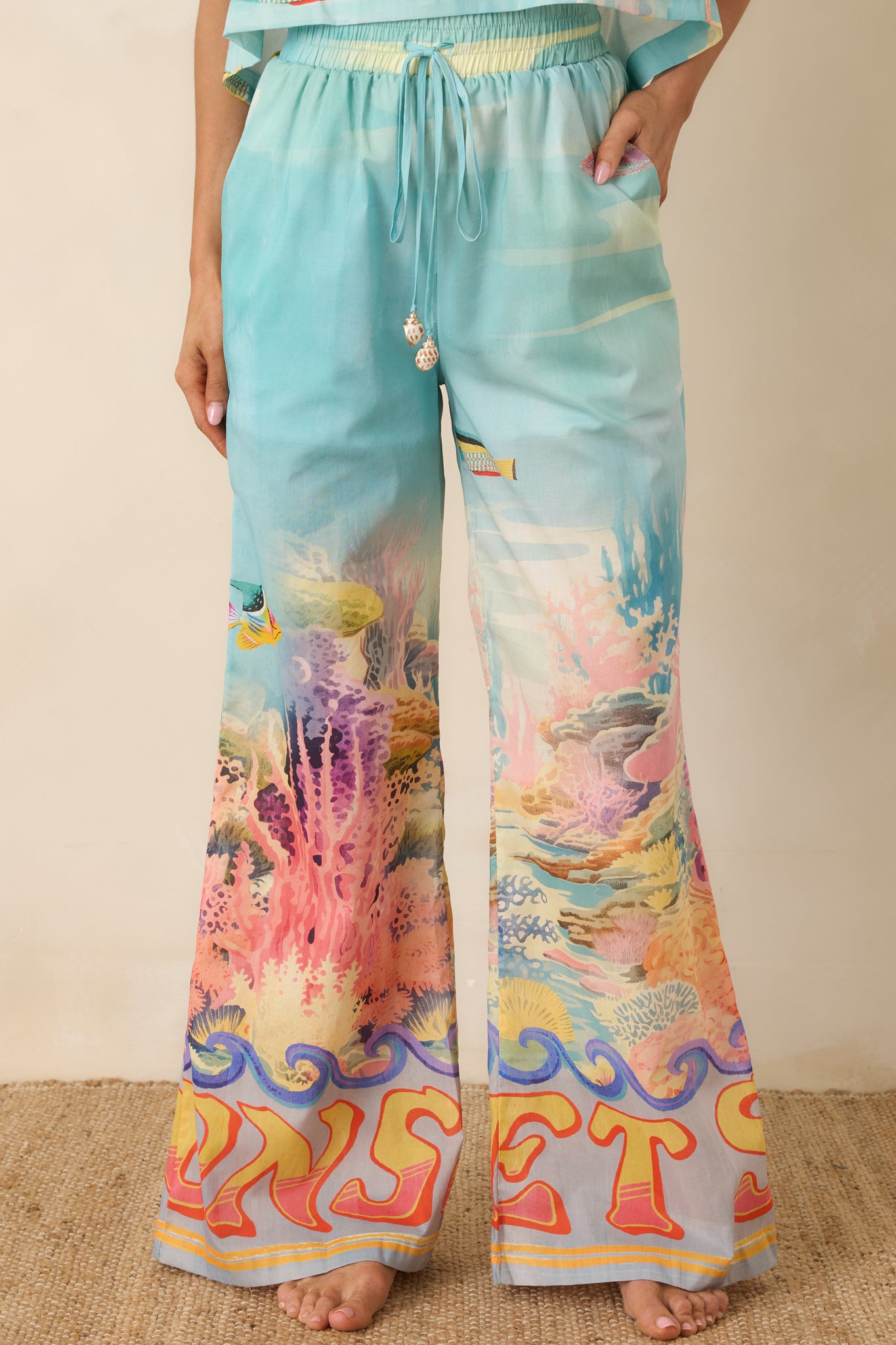 Detailed look at the colorful coral, sea life, and wave motifs across the pants.