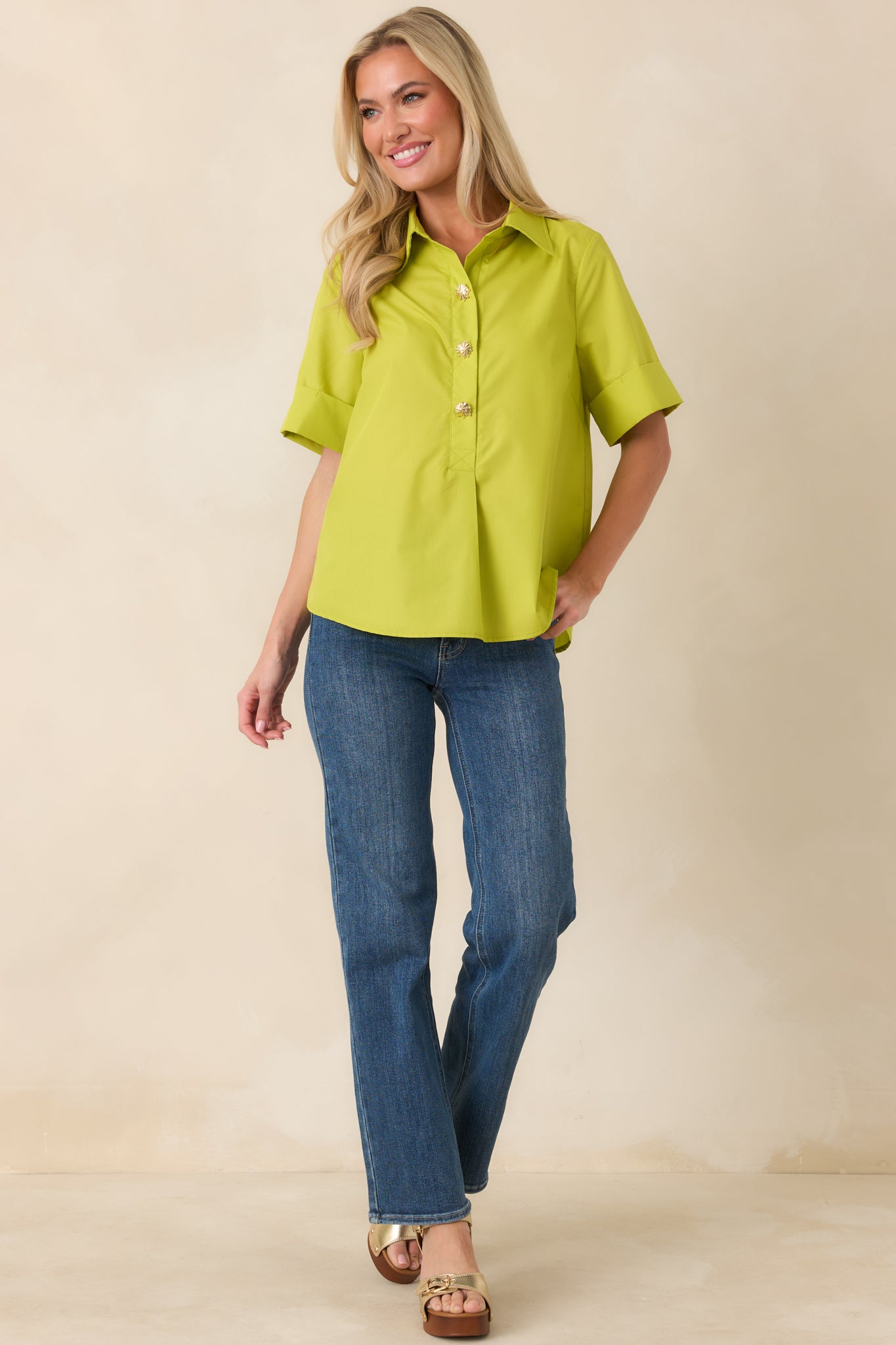 Front view of a boxy green blouse featuring cuffed short sleeves, subtle rounded hemline, and lightweight fabric for a clean drape.