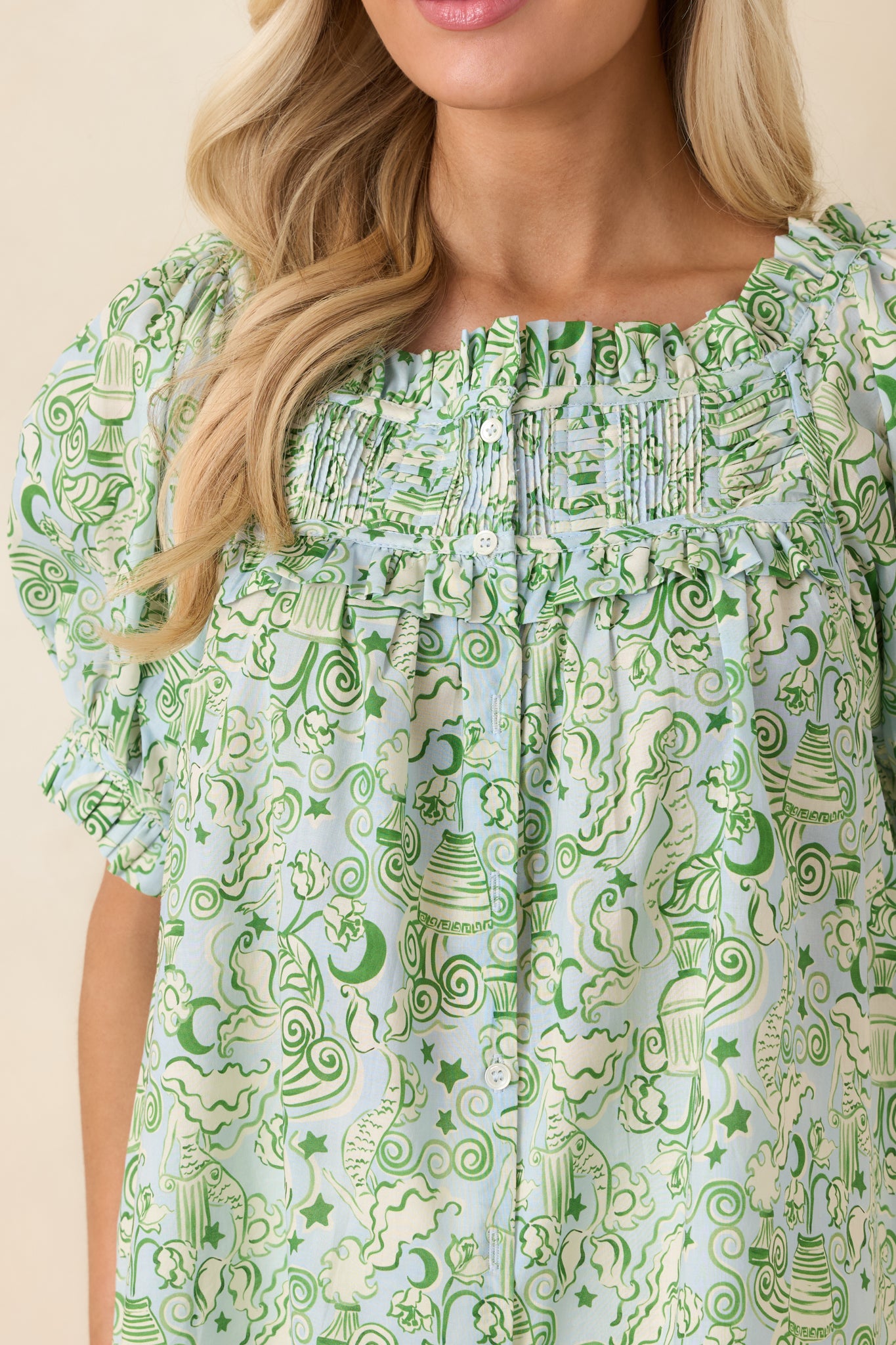 Detailed pintuck stitching and button-front closure on blue and green cotton fabric.