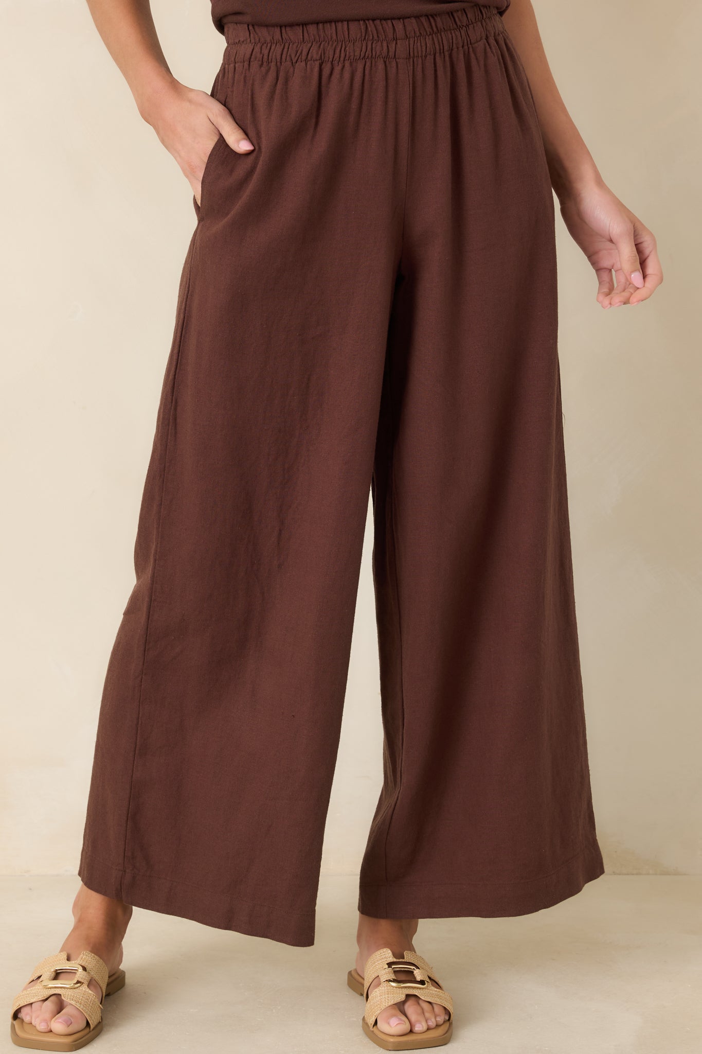 Mid-section close-up emphasizing side pockets, relaxed fit, and chocolate brown color.