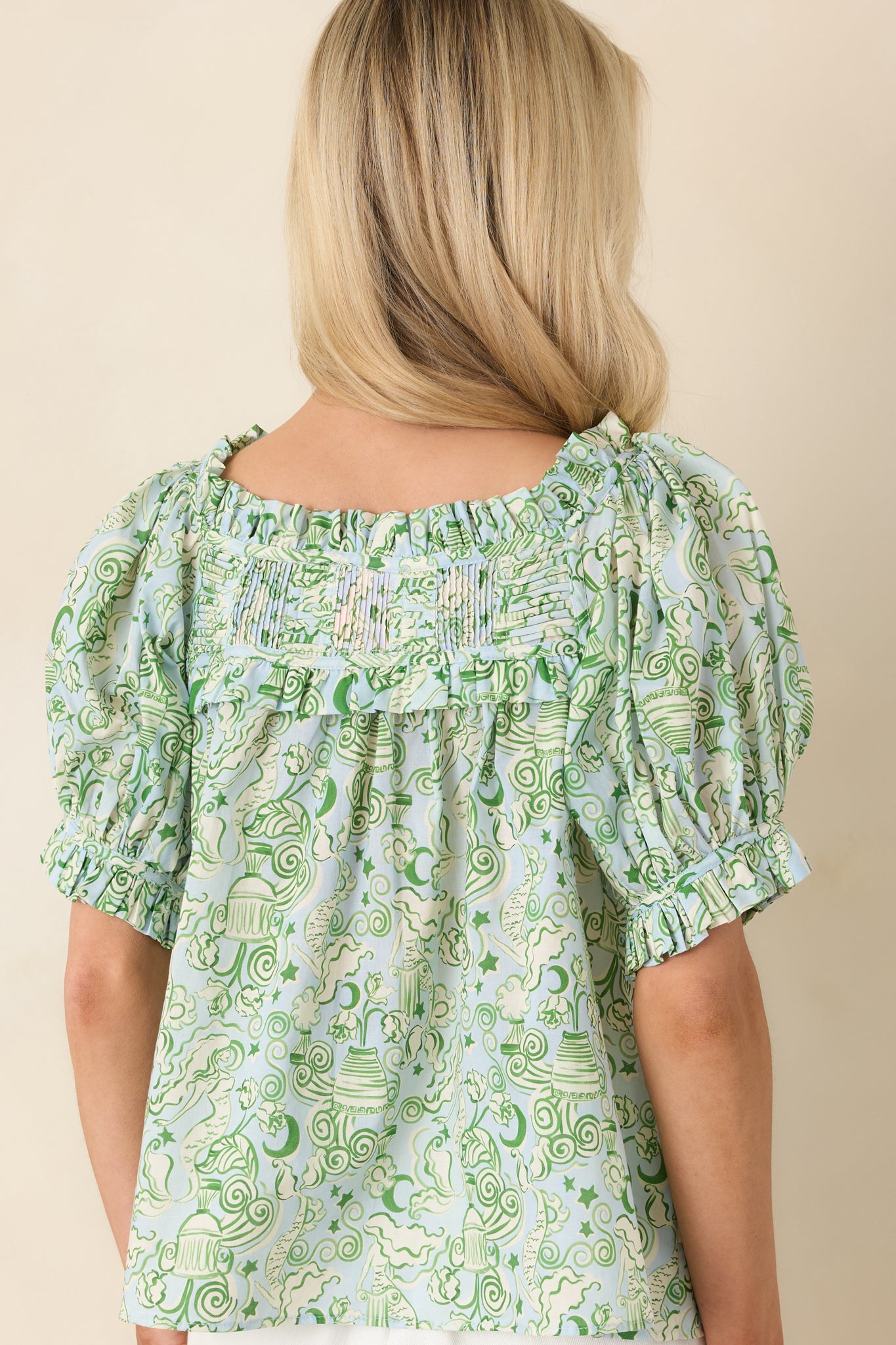 Rear view of blue and green blouse featuring relaxed silhouette and pintuck detailing along the back yoke.