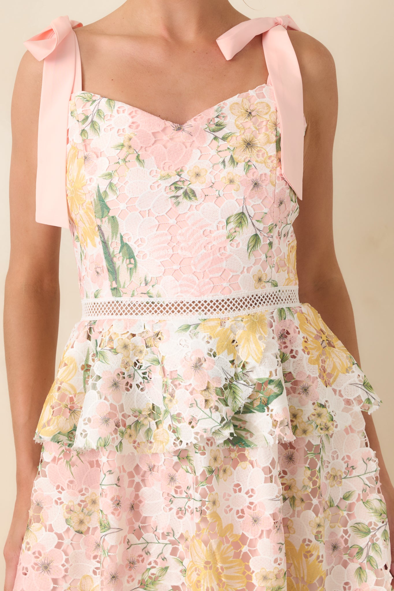 Close-up of the knitted lace overlay and soft floral print on the peach midi dress.