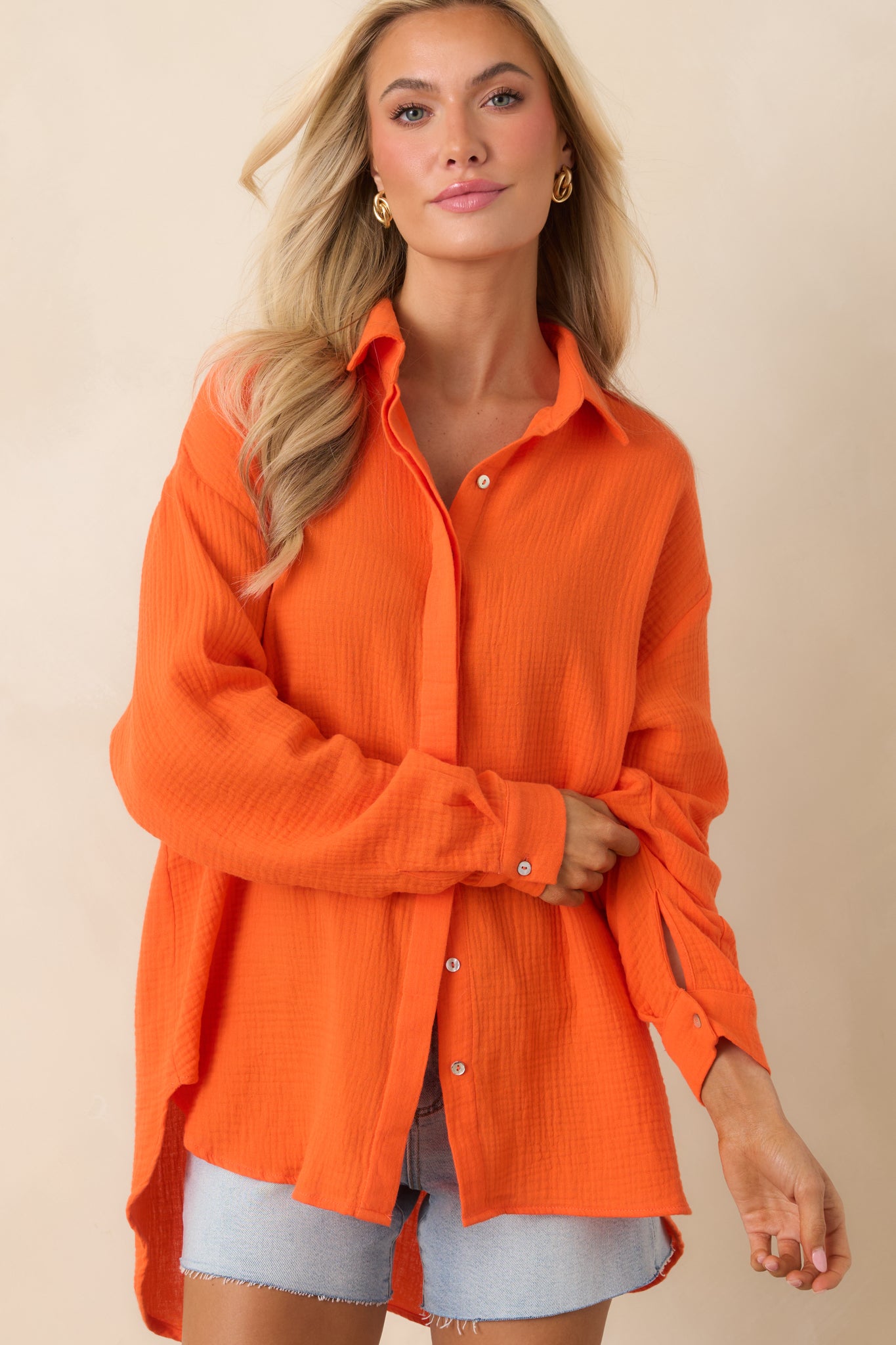 Orange button-up highlighting high-low hemline and soft lightweight fabric.
