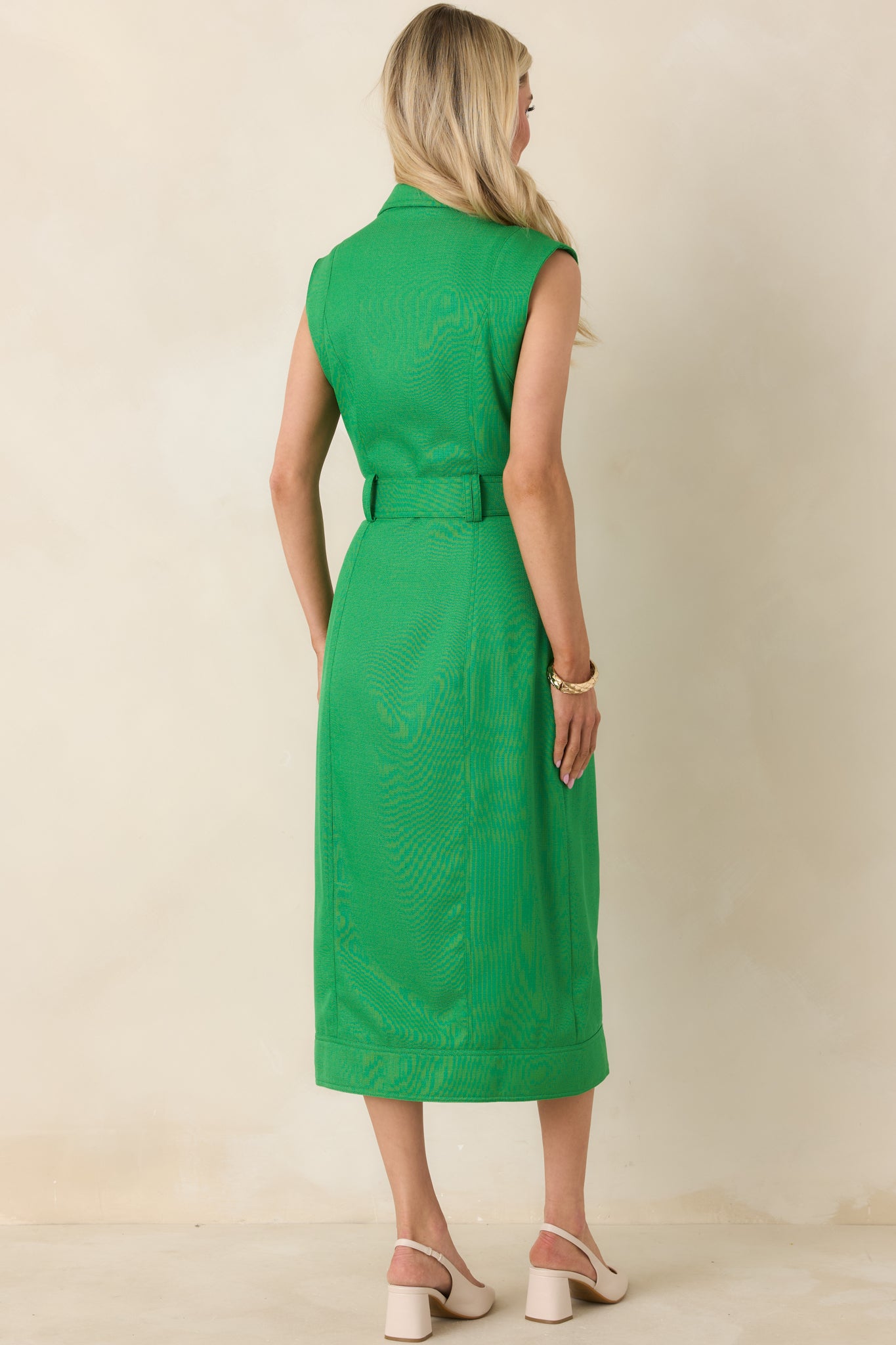 Rear view of green sleeveless midi dress showing smooth fabric, midi-length hem, and streamlined shape.