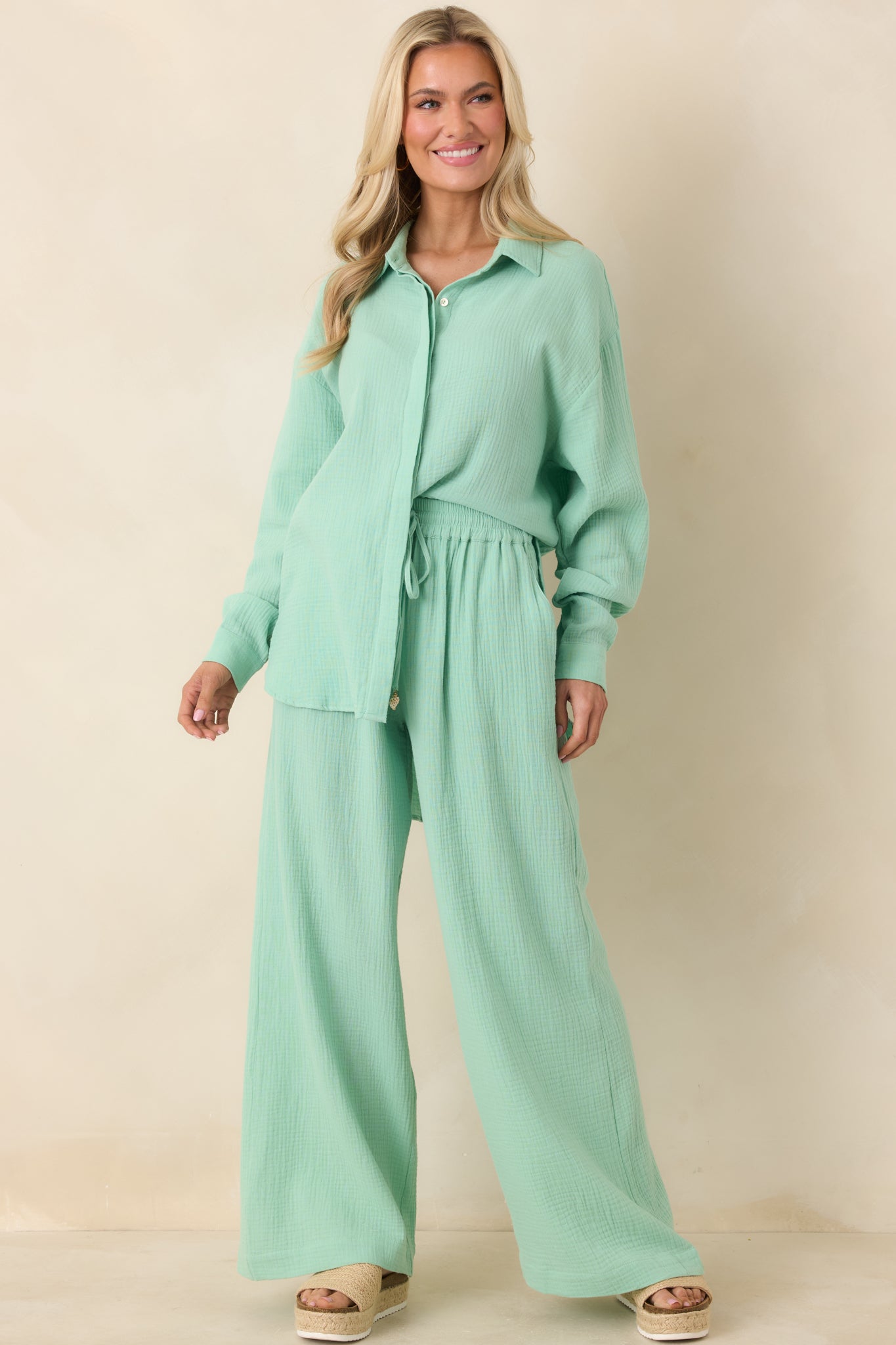 Seafoam green wide-leg cotton pants with elastic waistband, adjustable tassel drawstring, and full-length flowy silhouette.