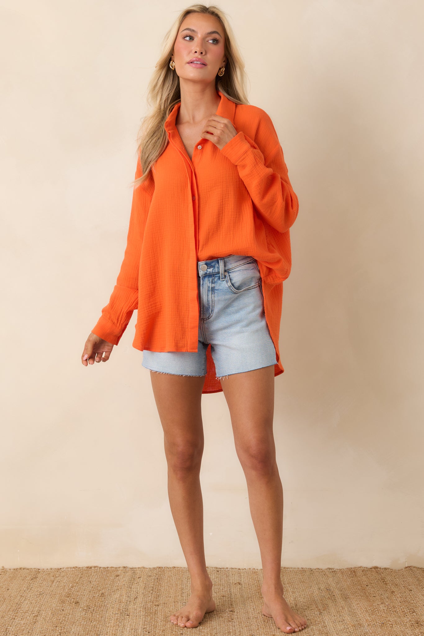 Relaxed-fit orange shirt with long sleeves, roll-tab styling, and versatile front closure.