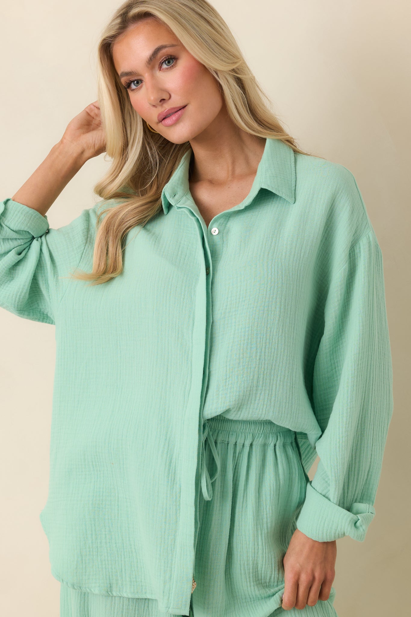 Long sleeve cuff with roll-tab button detail on light green textured cotton button-up.