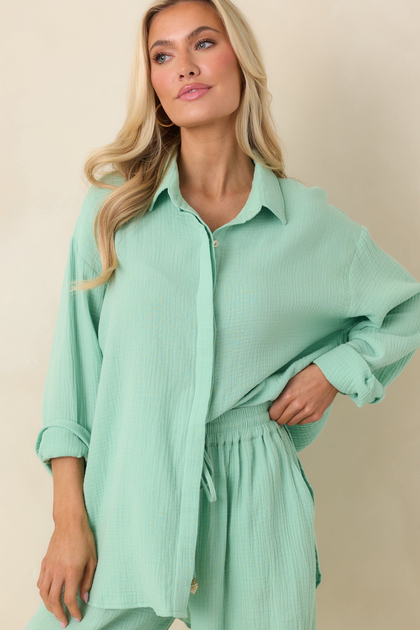 Collared neckline and front button placket on light green gauze cotton fabric.