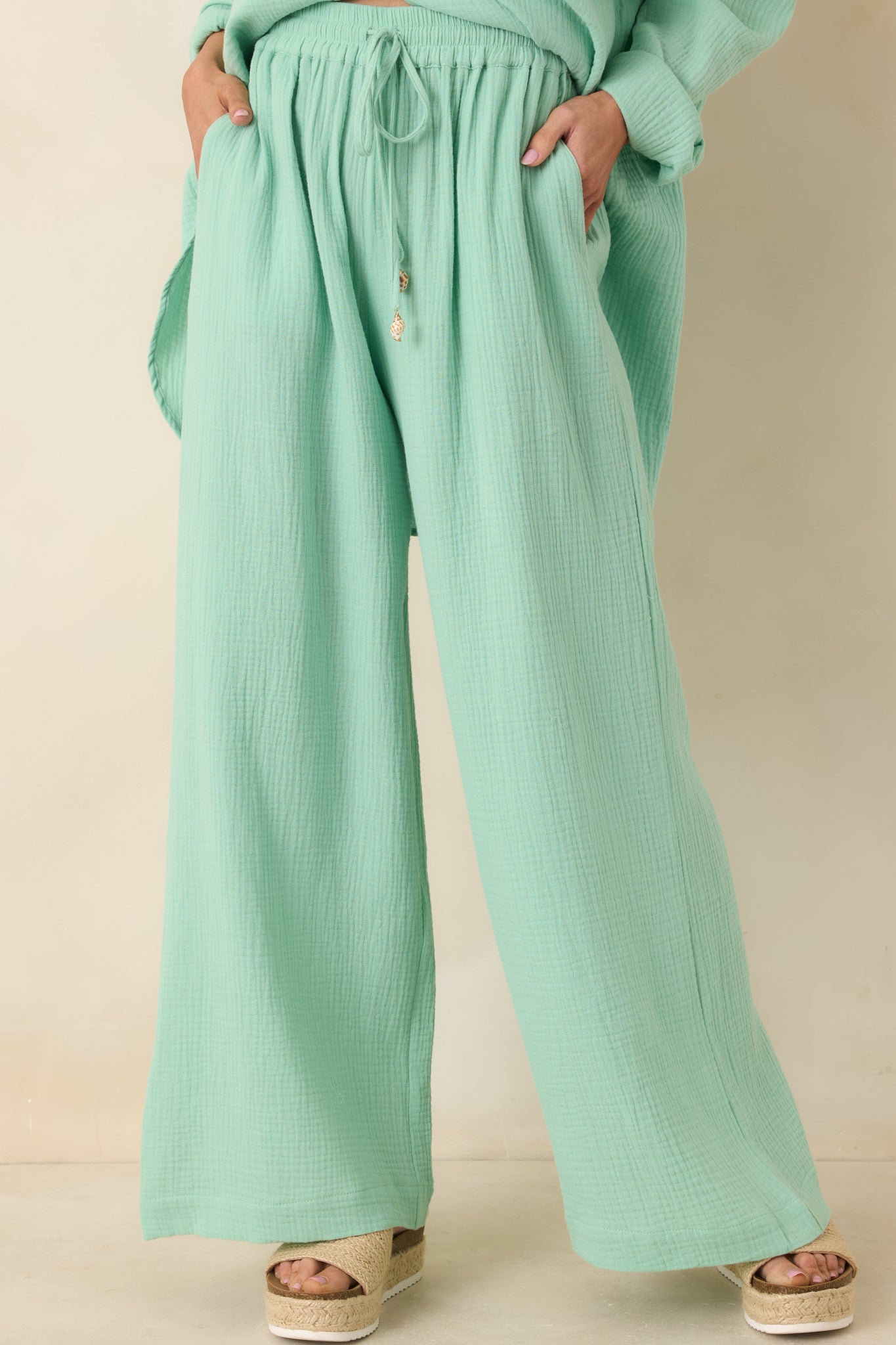 Seafoam green gauze pants highlighting relaxed wide-leg shape and lightweight woven texture.