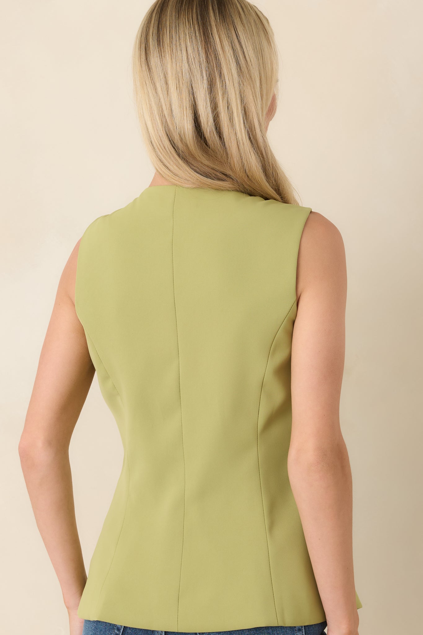 Rear view of the green sleeveless top displaying the smooth fully lined finish and tailored princess seam shaping.