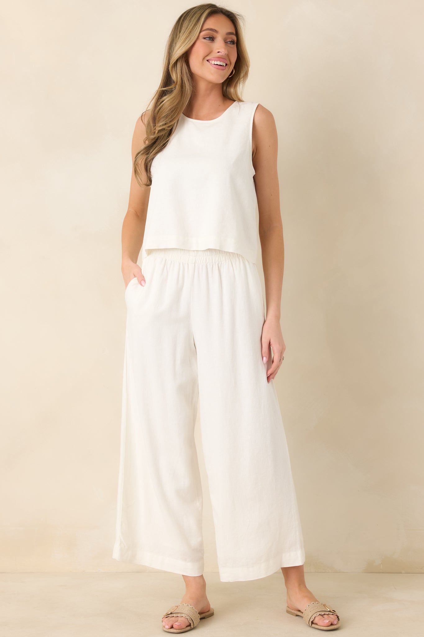 Lightweight white linen pants featuring a flowy wide-leg silhouette, soft elastic waistband, and effortless ankle-length finish for warm-weather comfort.