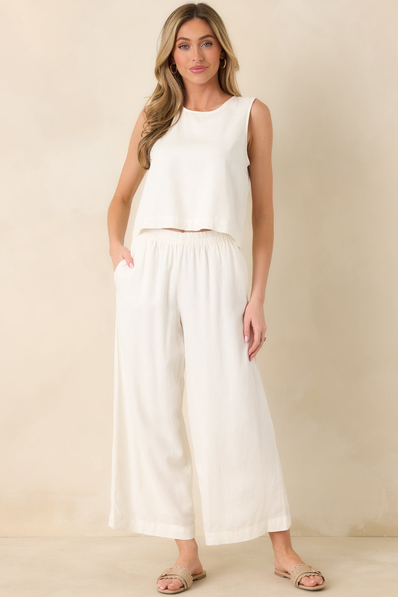 Airy white linen pants with a naturally relaxed shape, elastic pull-on waist, roomy wide legs, and practical side pockets for everyday wear.