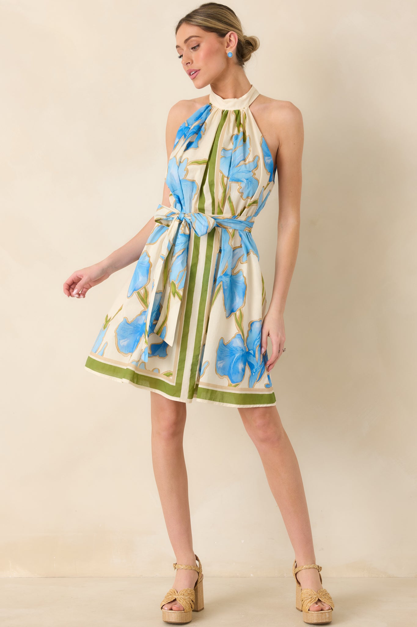 Mini dress with blue floral print on ivory fabric and olive green stripe accents.