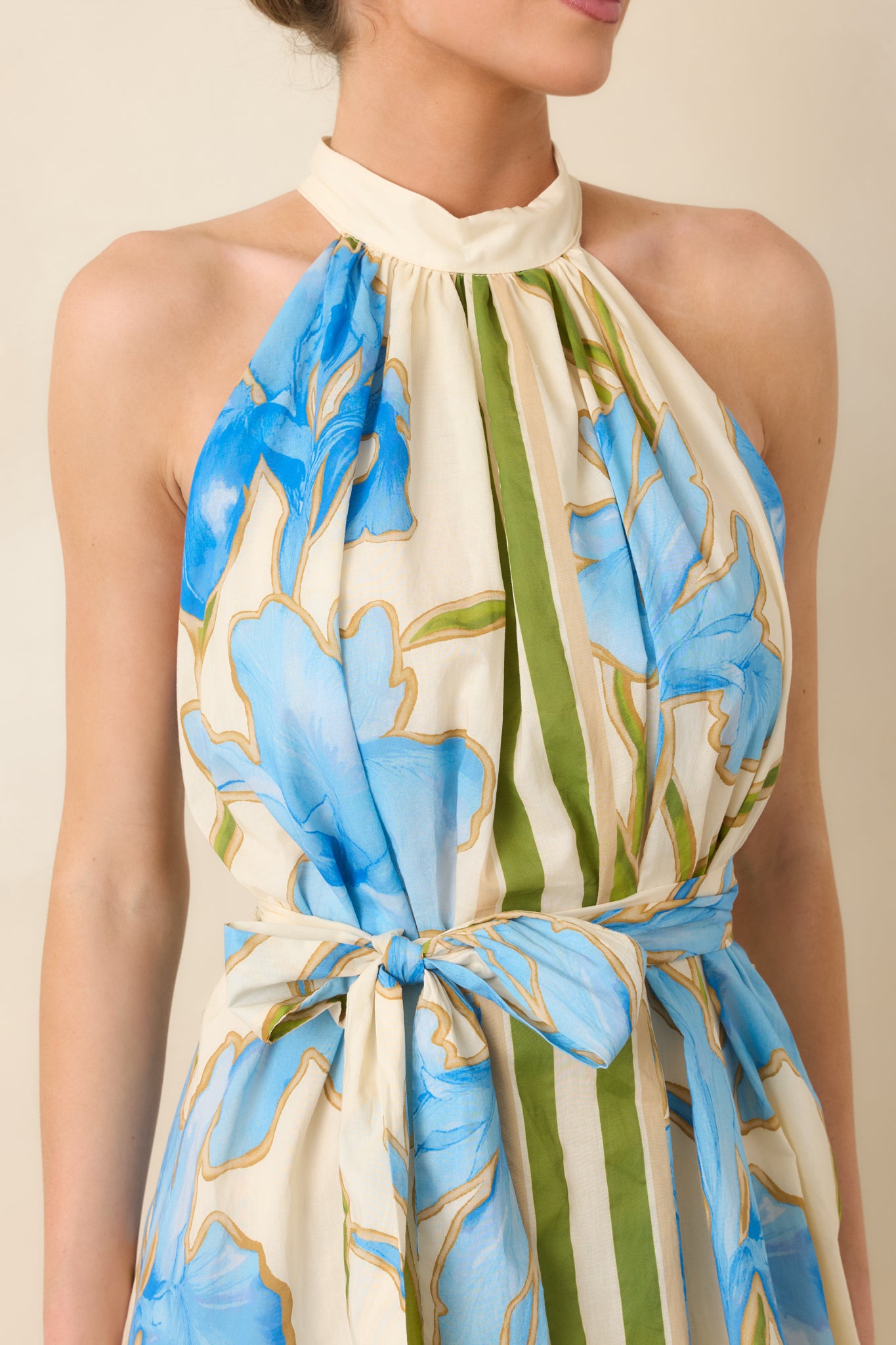 Detailed view of blue floral print with olive green stripe accents and soft ivory backdrop.