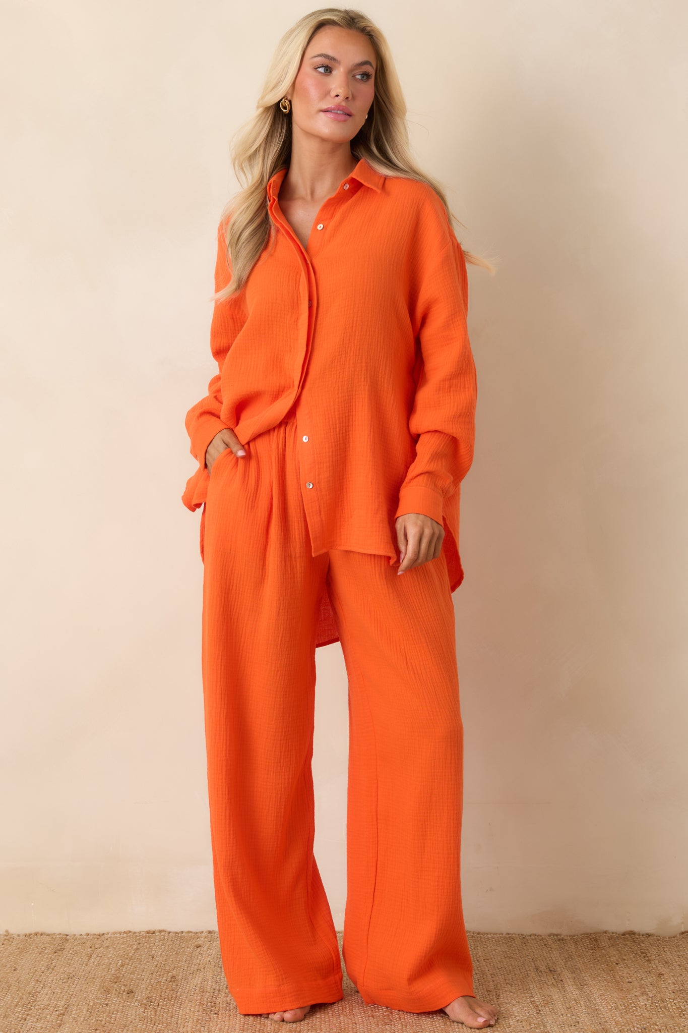 Bright orange textured cotton pants with an elastic waistband, adjustable drawstring, and a relaxed wide-leg silhouette.