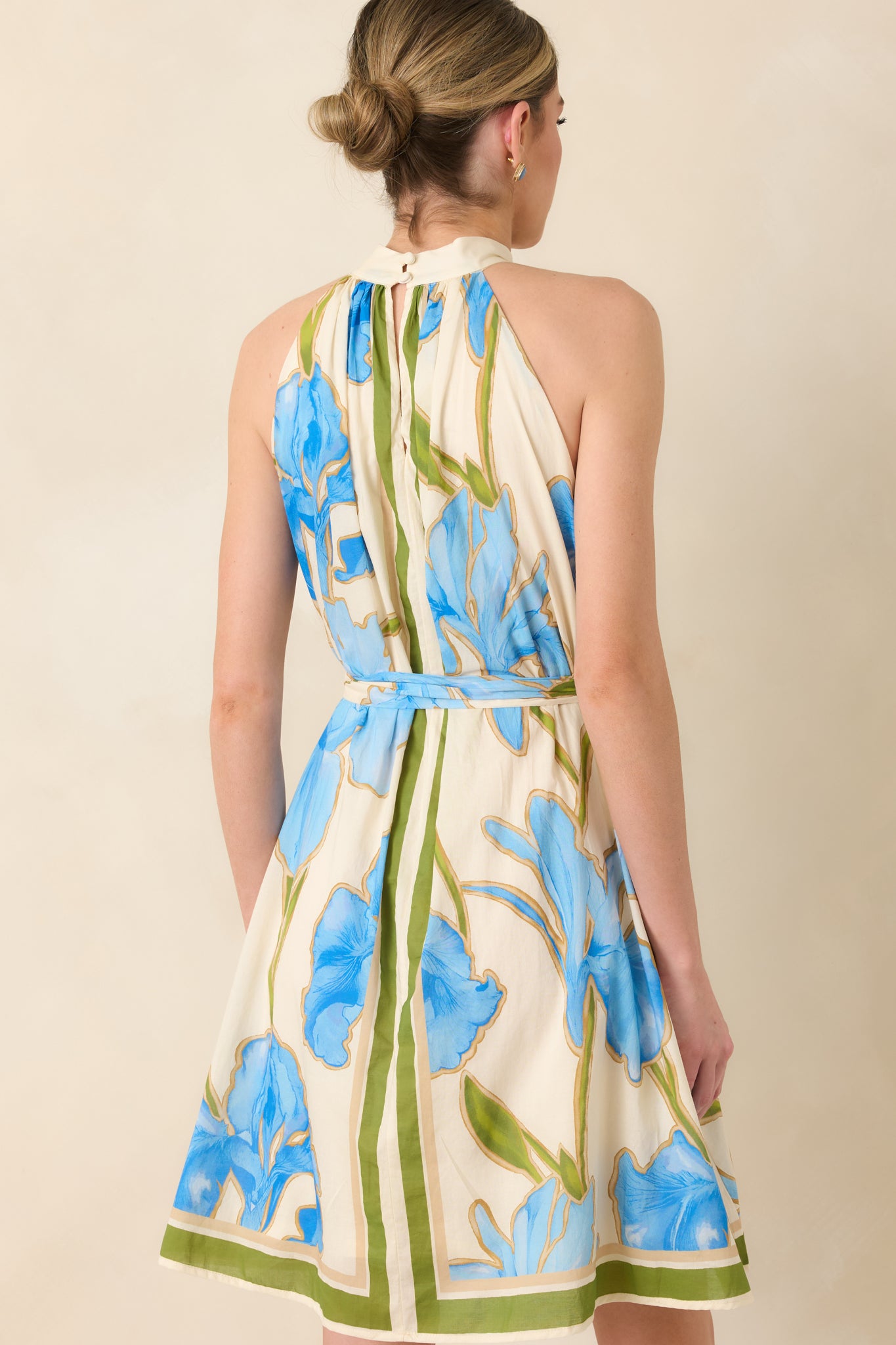 Rear view of mini dress with halter neckline, self-tie belt, and flowing skirt.